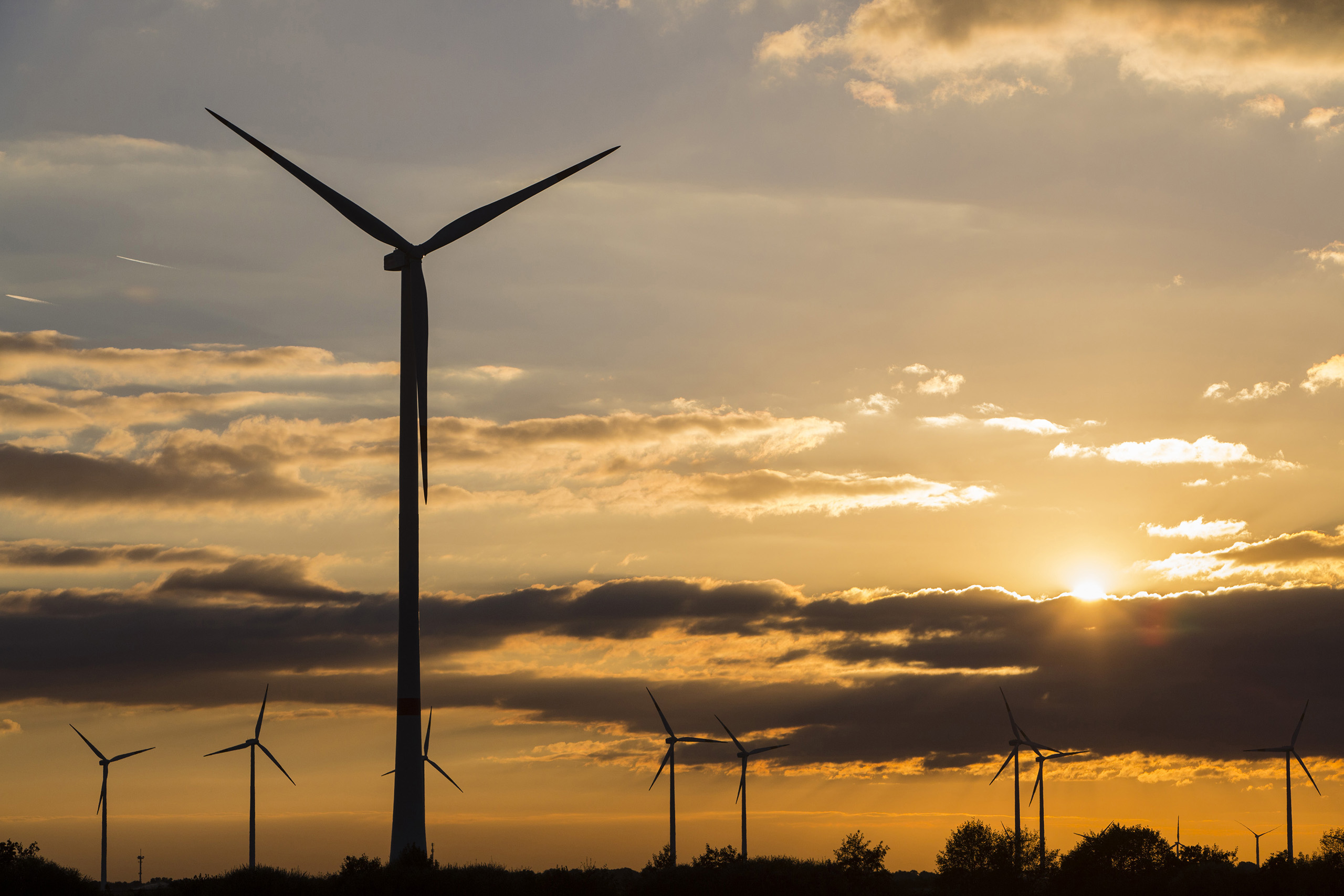Wind turbines operate on the Innogy SE wind farm as the sunsets in Bedburg, Germany, on Oct. 4, 2016.