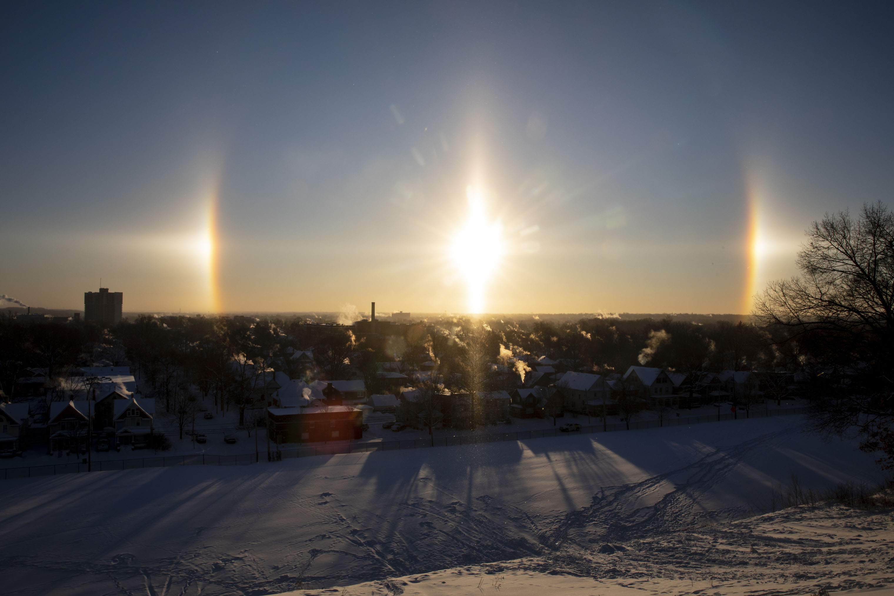 A concentrated patch of sunlight, known as a sun dog, appears to the left and right of the sun over downtown Kalamazoo, Mich. on Thursday, Jan. 31, 2019.