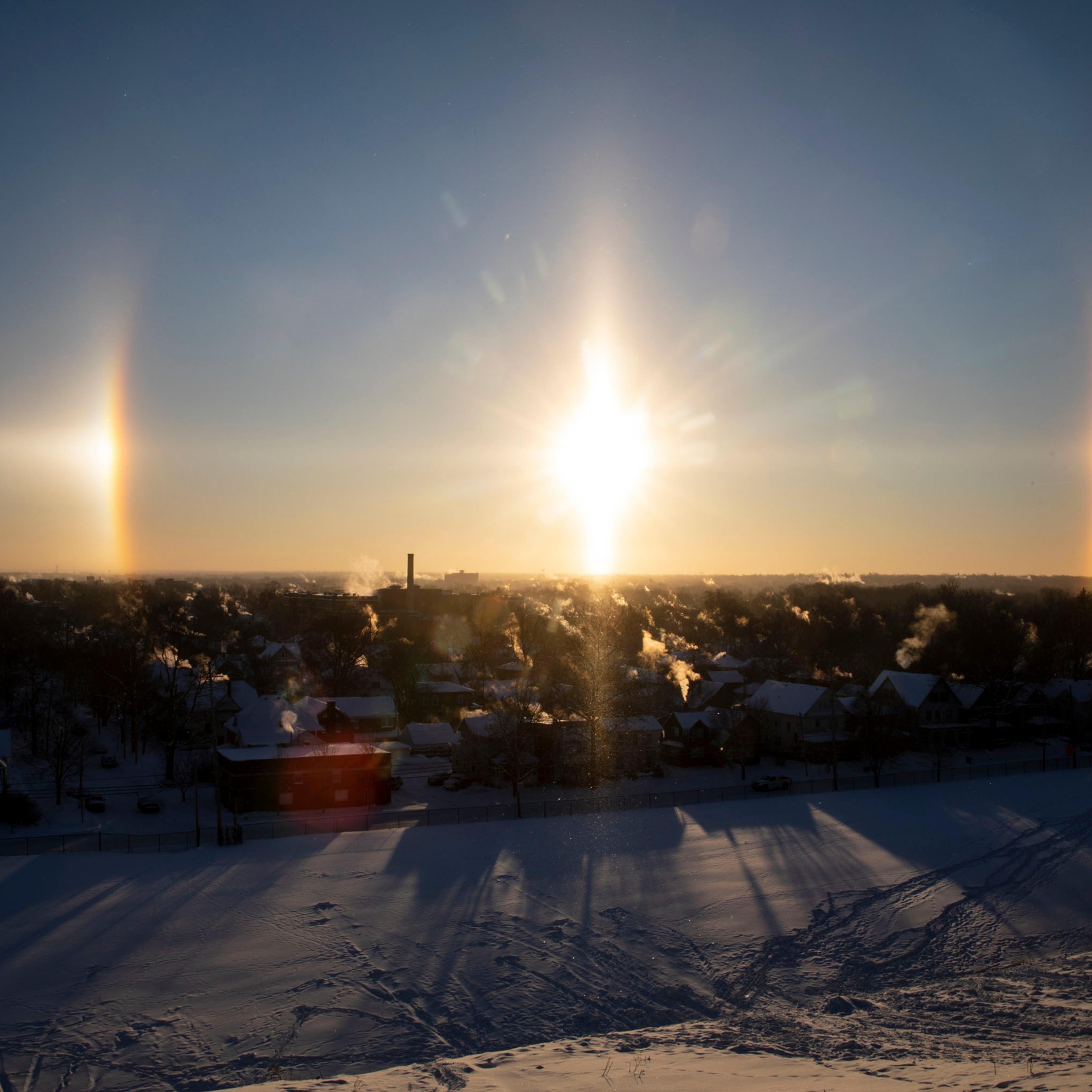 A concentrated patch of sunlight, known as a sun dog, appears to the left and right of the sun over downtown Kalamazoo, Mich. on Thursday, Jan. 31, 2019.