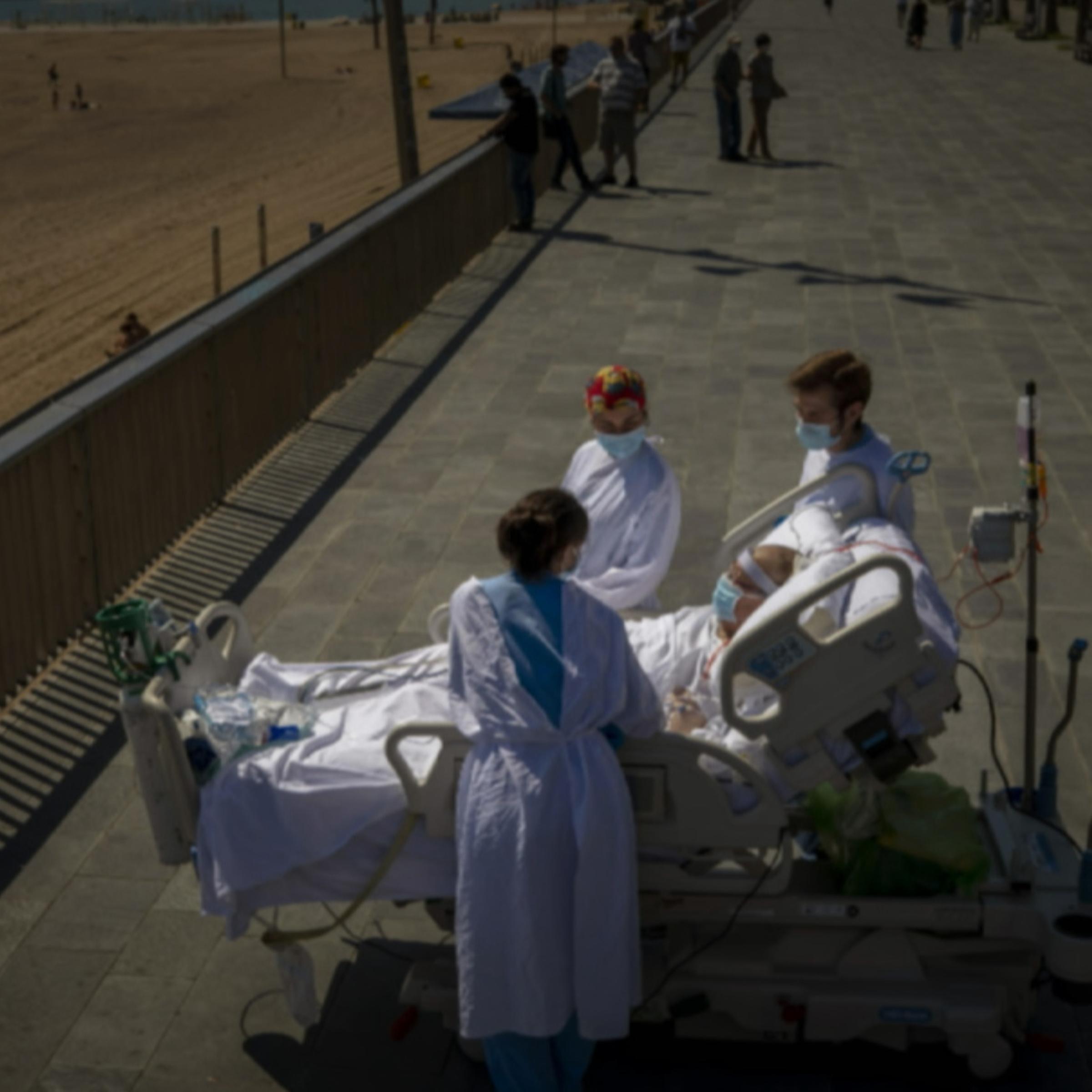 Francisco Espana, 60, is surrounded by members of his medical team as he looks at the Mediterranean sea from a promenade next to the “Hospital del Mar” in Barcelona, Spain, Friday, Sept. 4, 2020.