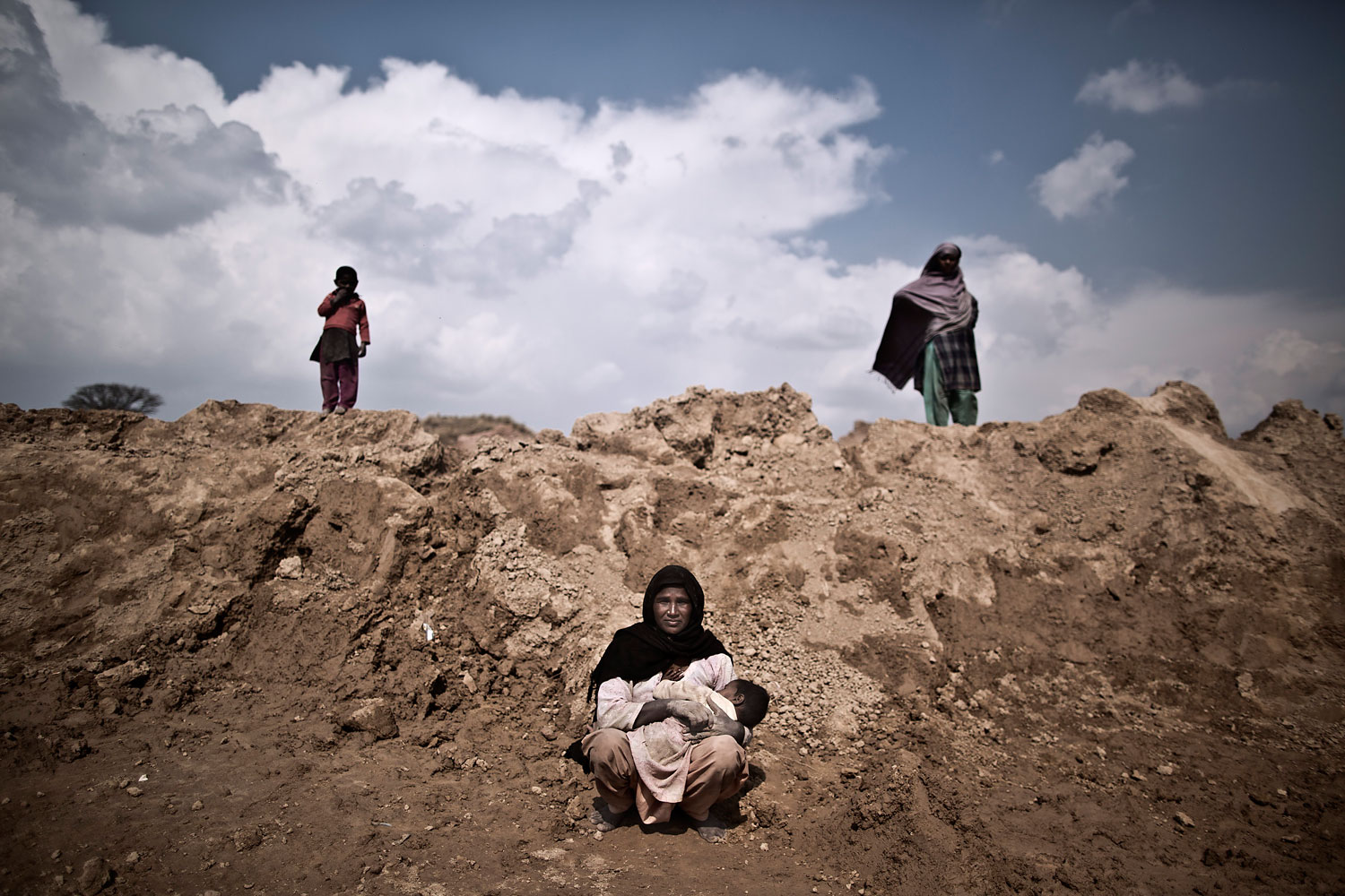Ghaziya Iqbal, 35, a Pakistani brick factory worker, breast-feeds her child Farman, 9 months old, at the site of her work on the outskirts of Islamabad, Pakistan, March 2, 2014. Ghaziya and her husband are in debt to their employer the amount of 250,000 