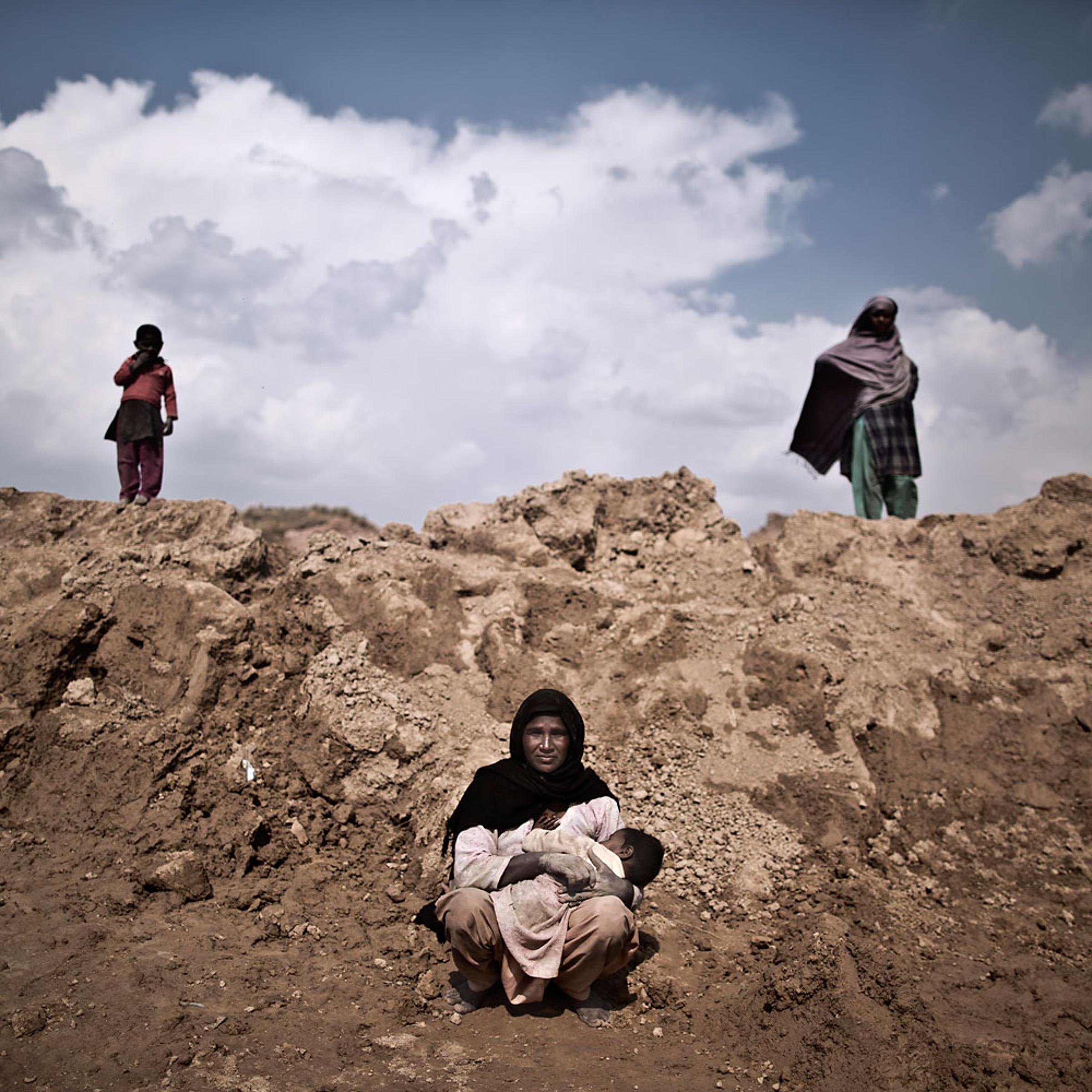 Ghaziya Iqbal, 35, a Pakistani brick factory worker, breast-feeds her child Farman, 9 months old, at the site of her work on the outskirts of Islamabad, Pakistan, March 2, 2014. Ghaziya and her husband are in debt to their employer the amount of 250,000