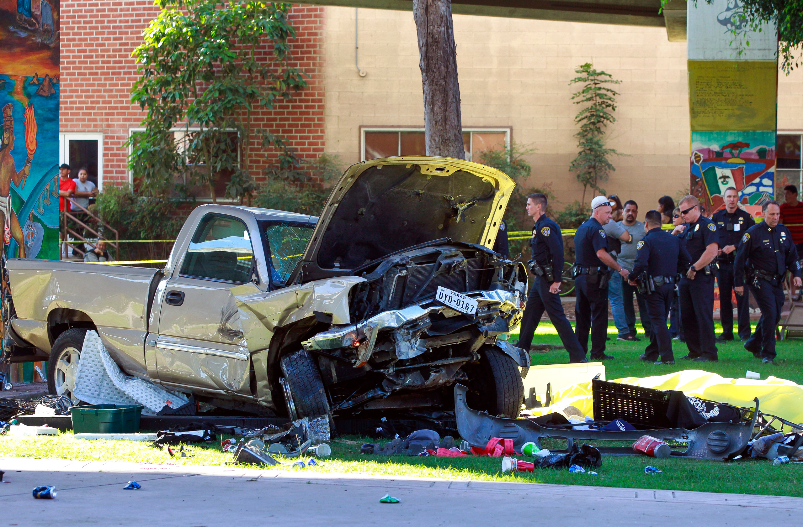 Police stand near the pickup truck that landed at Chicano Park after it flew off a ramp to the San Diego Coronado Bridge in San Diego on Saturday, Oct. 15, 2016. Four people were killed and nine were injured on Saturday after an out-of-control pickup tru