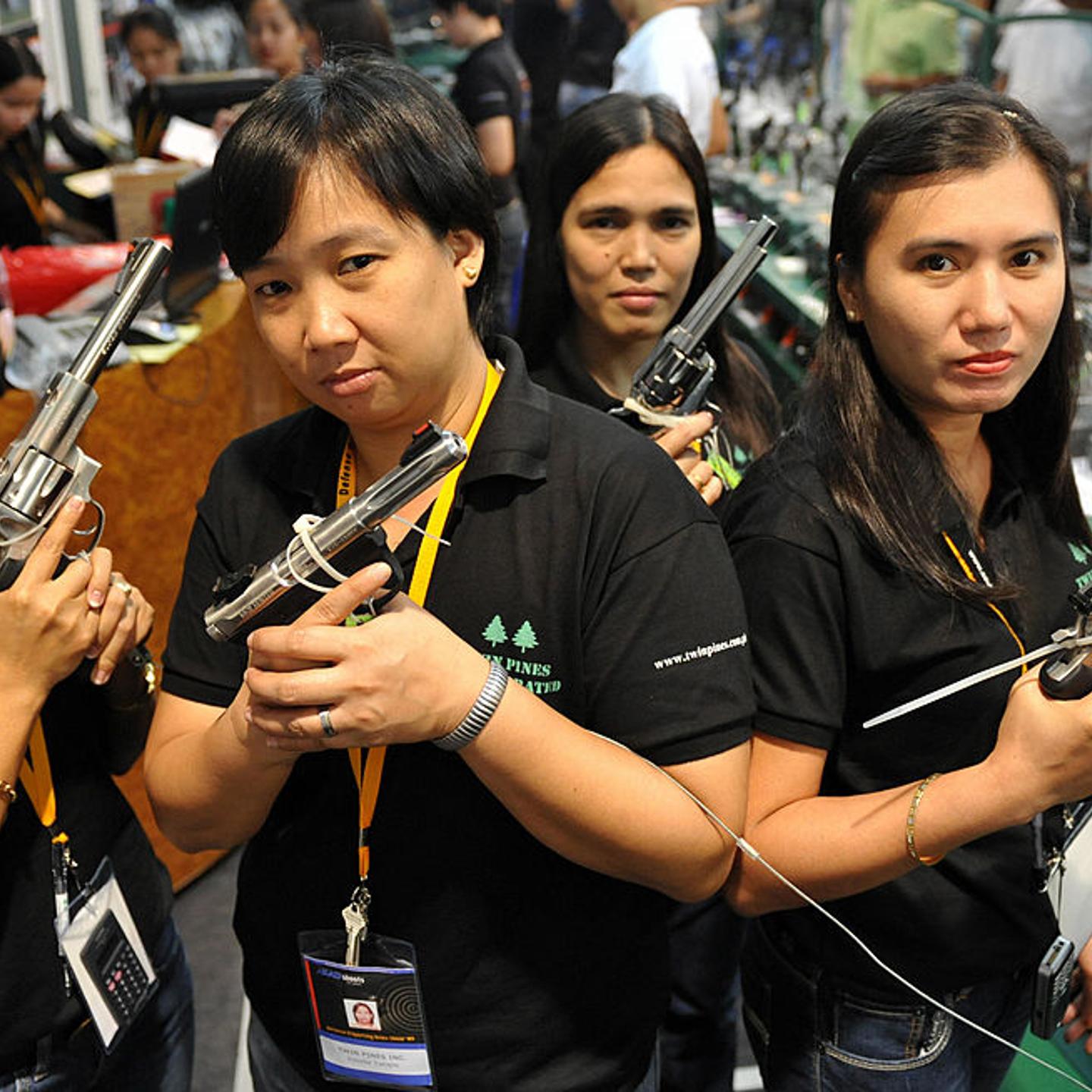 Shop assistants pose with various handgu