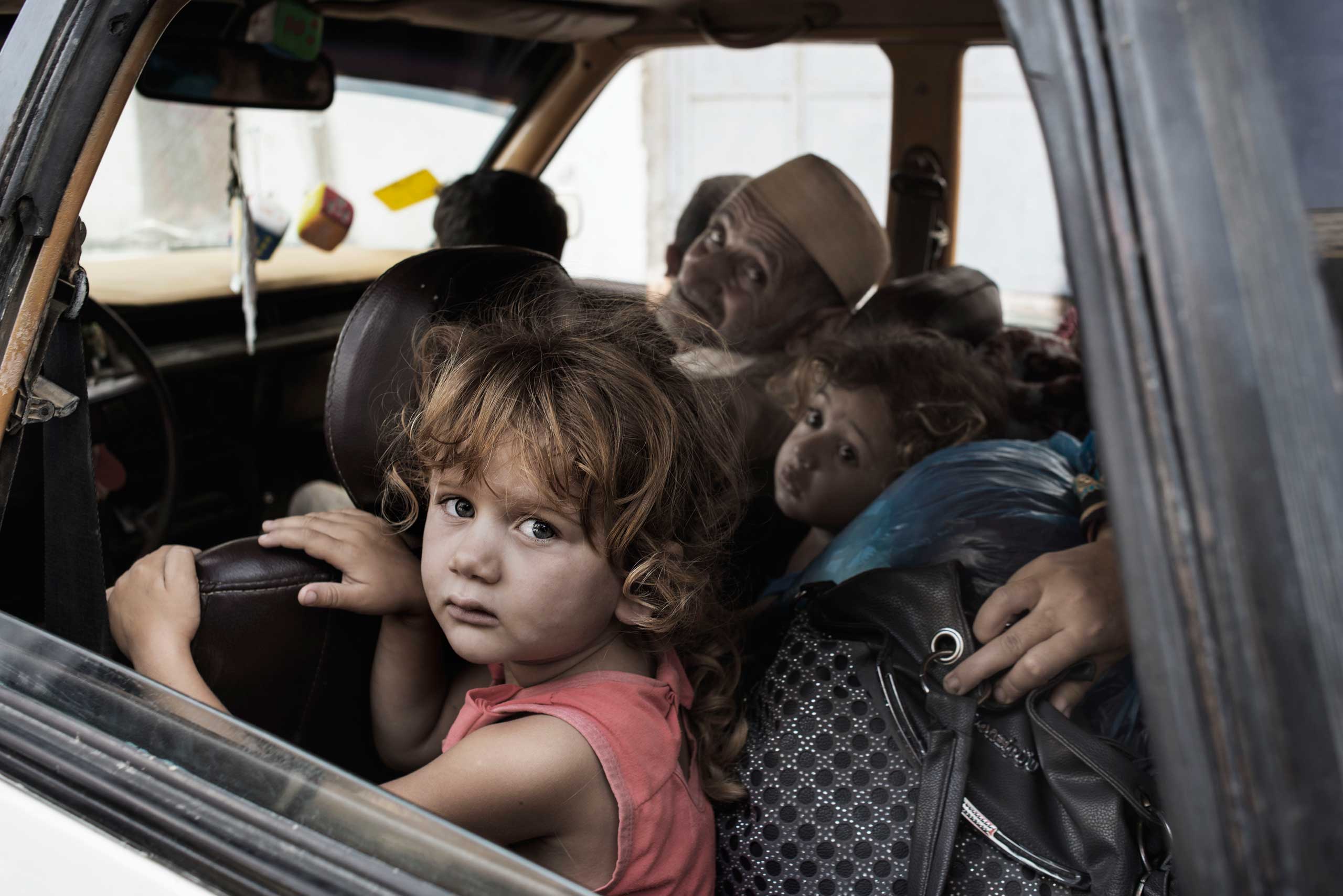 Palestinians seek shelter after evacuating their homes located near the border with Israel, July 13, 2014.
