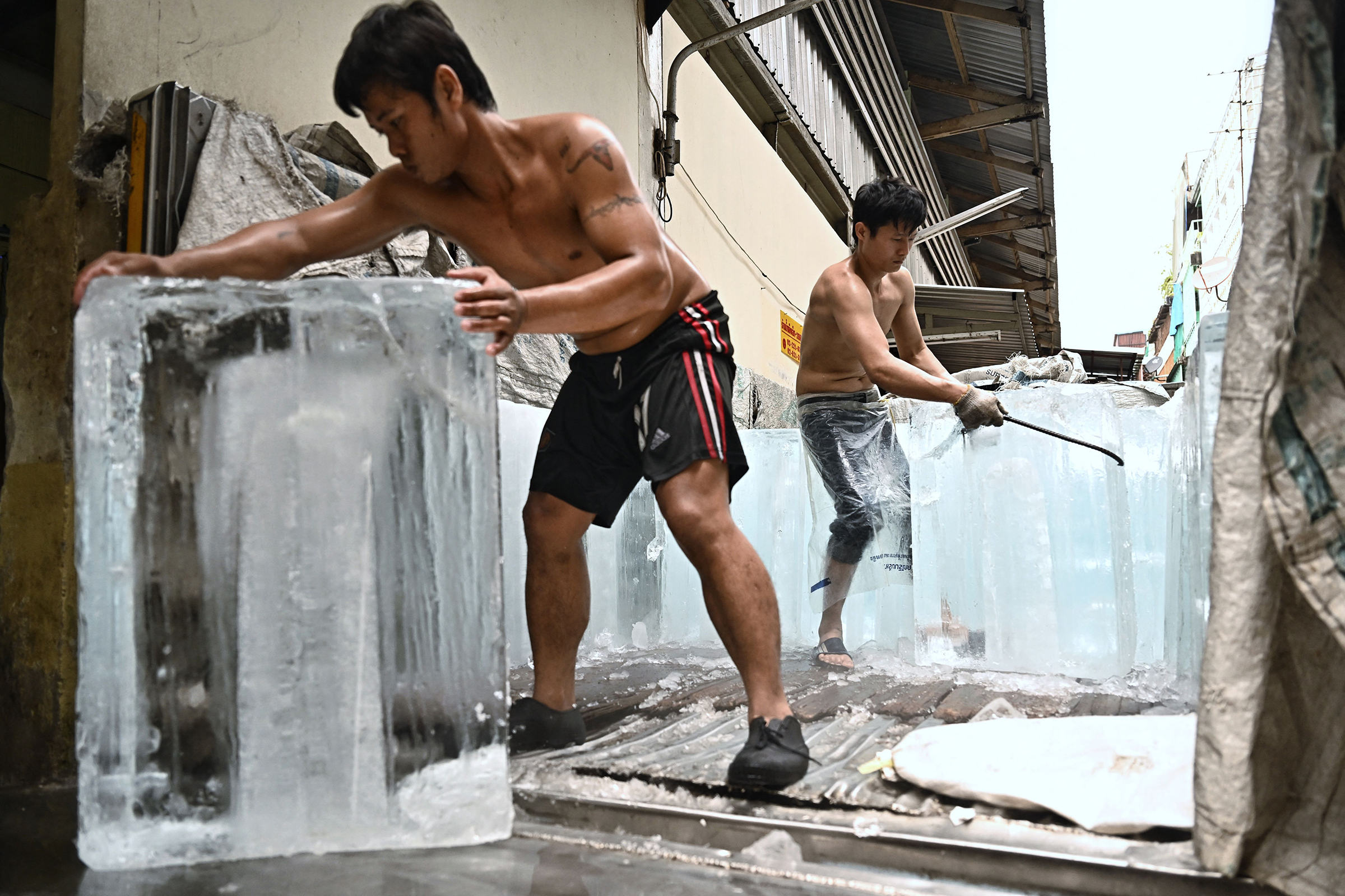 Workers move blocks of ice into a storage unit at a fresh market amid a heatwave in Bangkok, Thailand, on April 25.
