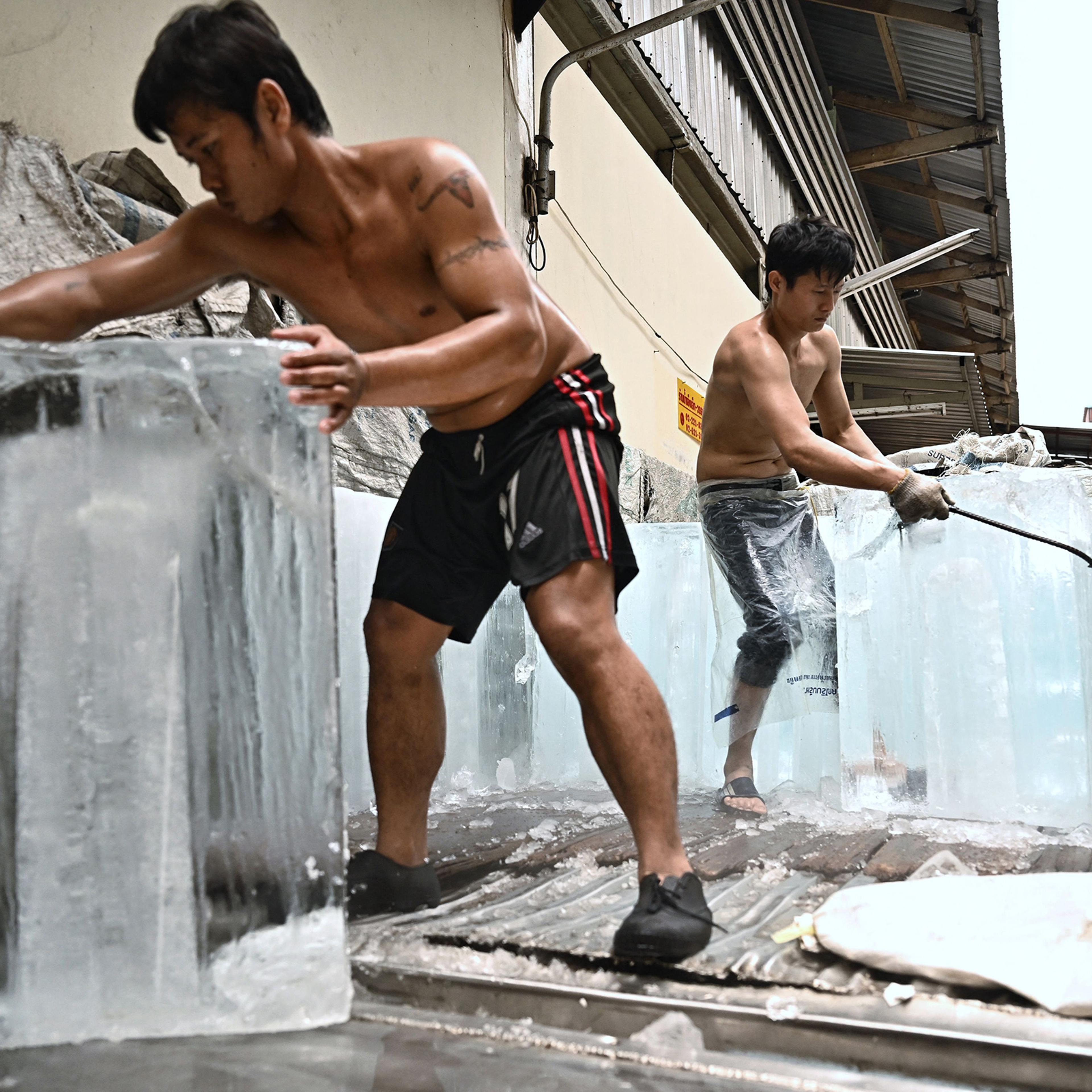 Workers move blocks of ice into a storage unit at a fresh market amid a heatwave in Bangkok, Thailand, on April 25.