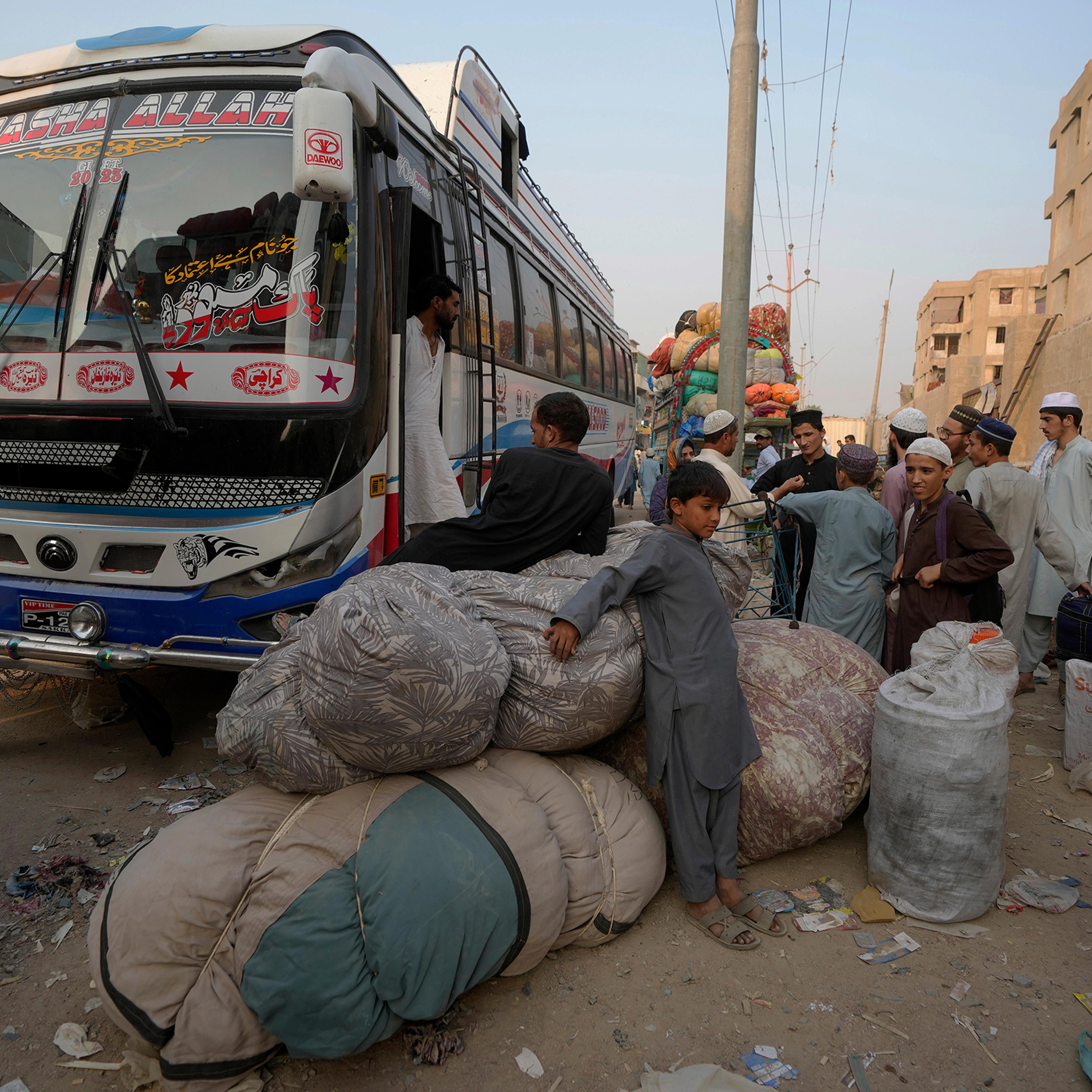 Afghan families wait to board in buses to depart for their homeland, in Karachi, Pakistan on Oct. 30.