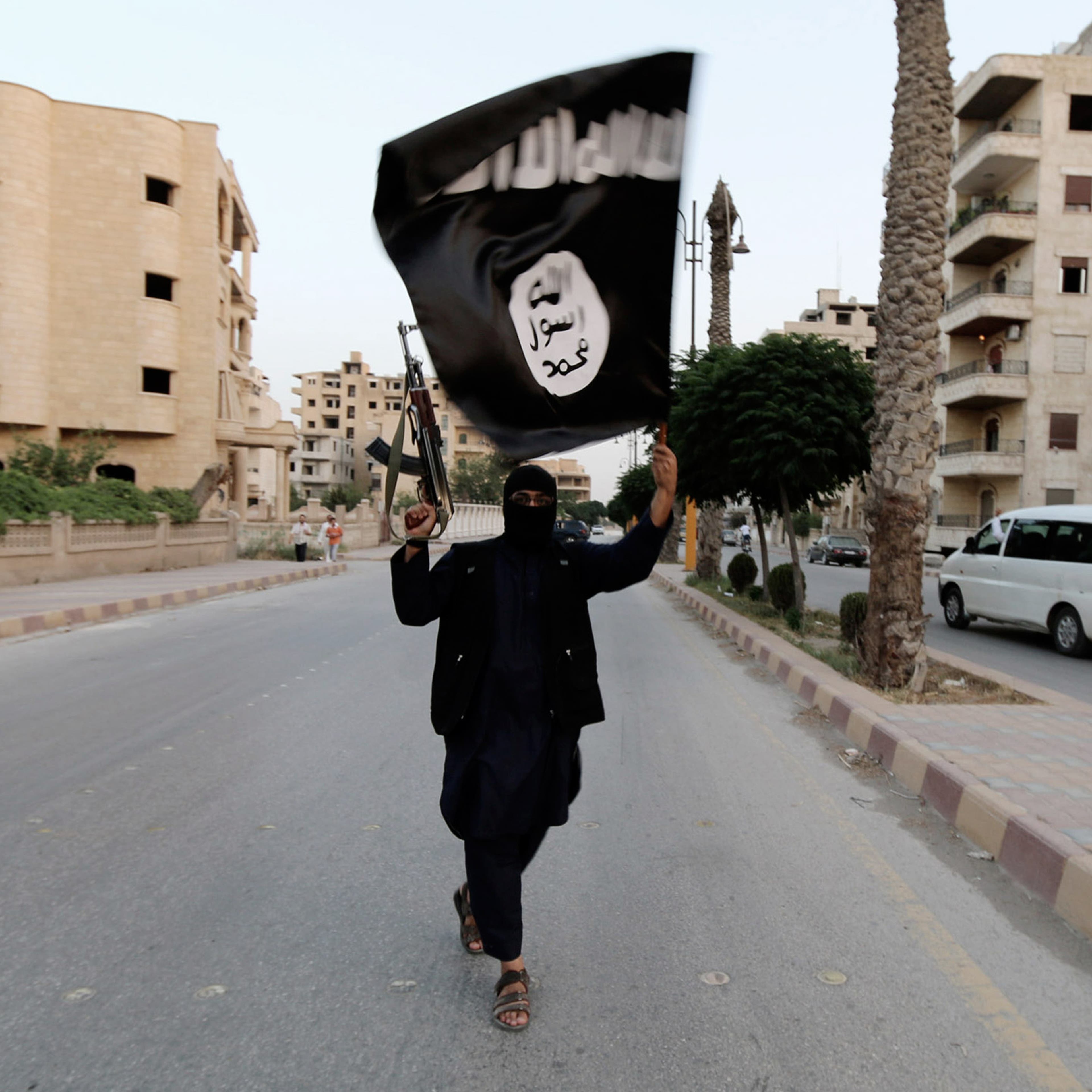 A member loyal to the Islamic State in Iraq and the Levant (ISIL) waves an ISIL flag in Raqqa on June 29, 2014.