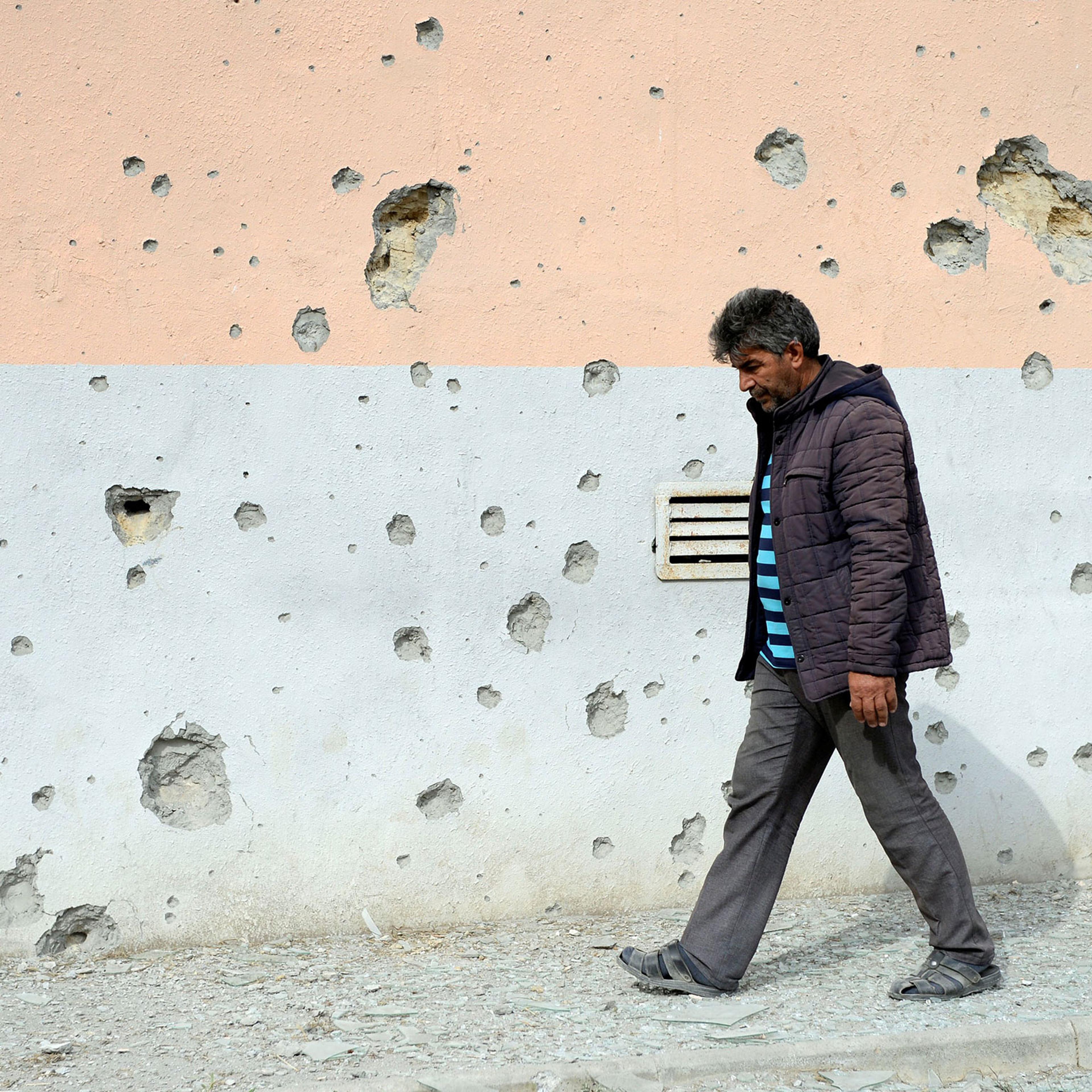 A man walks by a house that was damaged during clashes in the Tartar district bordering the Nagorno-Karabakh region