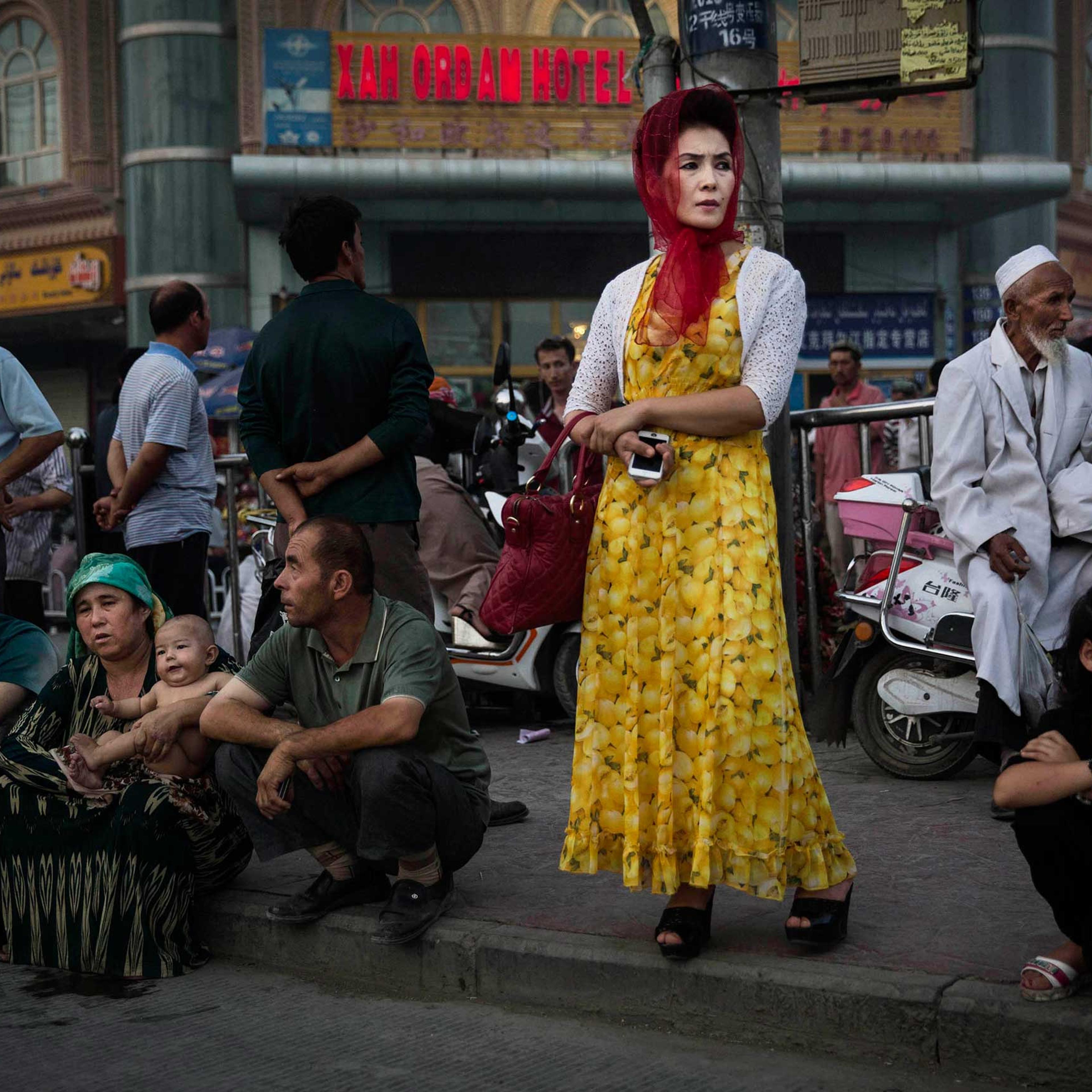 Uighurs wait at a bus stop in old Kashgar, Xinjiang Province, China, July 27, 2014.