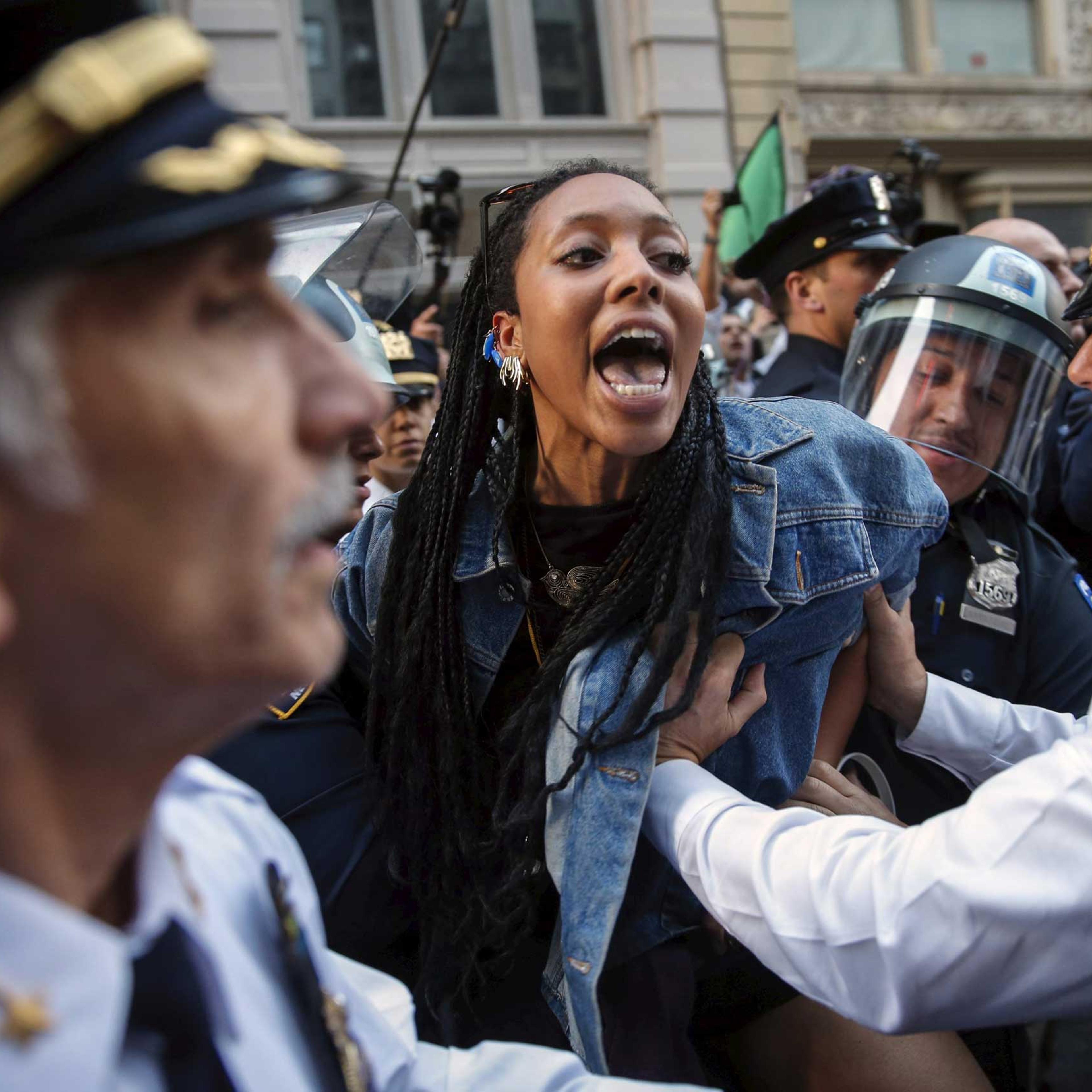 New York Police Department officers detain a protester during a march through the Manhattan borough of New York City on April 29, 2015.