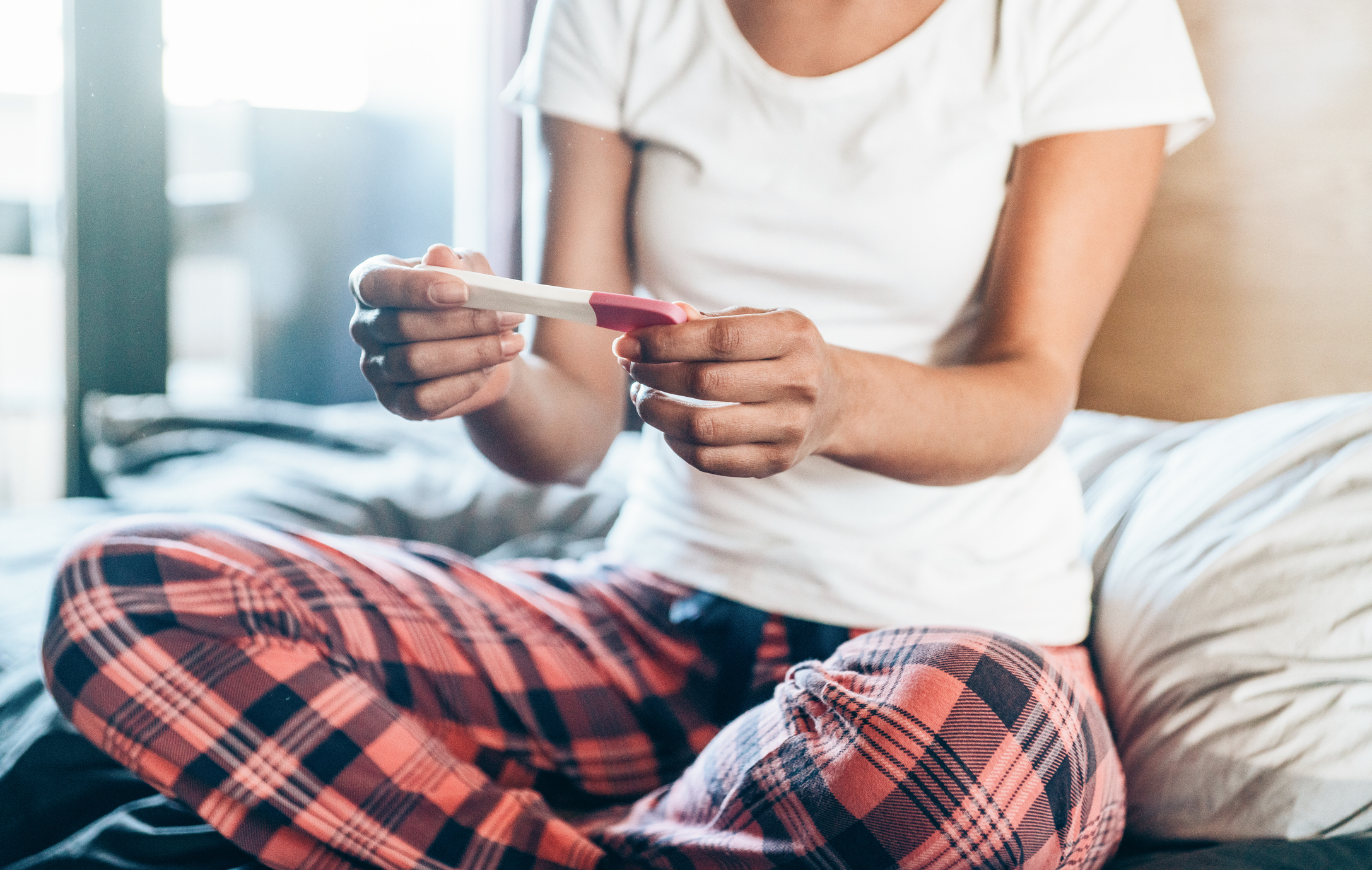 Sad Young Woman With Pregnancy Test At Home
