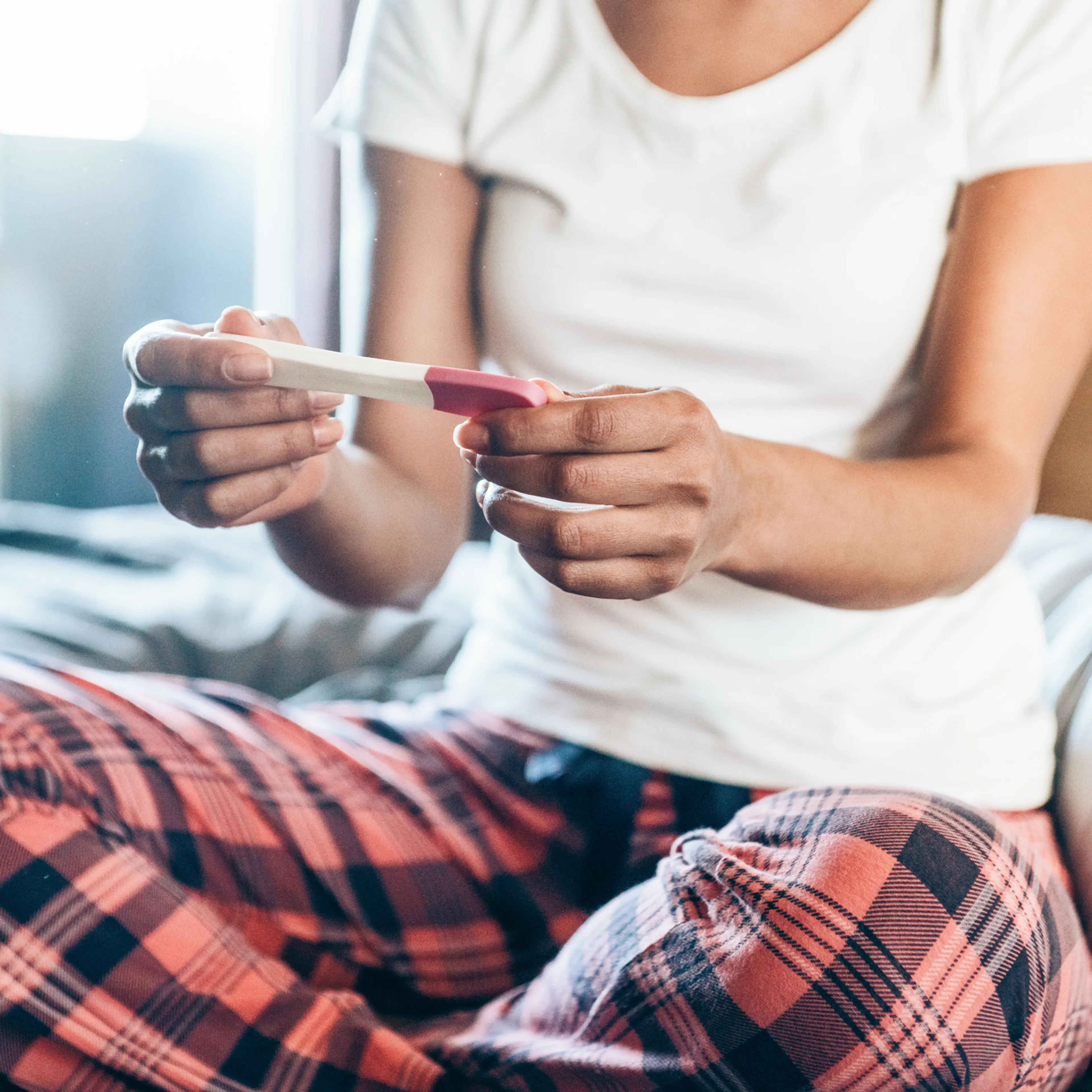 Sad Young Woman With Pregnancy Test At Home