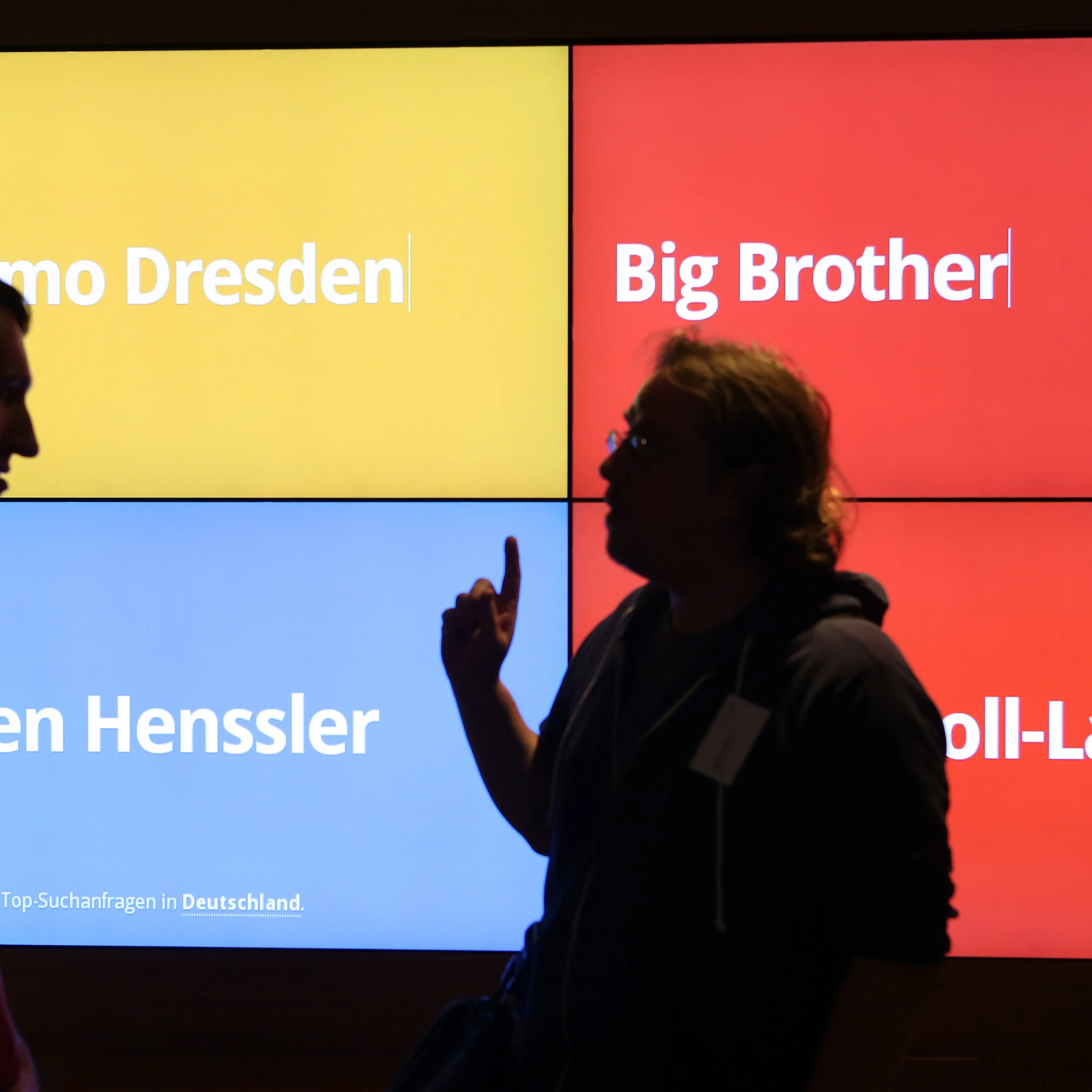 Visitors stand in front of a screen showing the most popular Google searches in Germany at that moment in the company's offices on Aug. 21, 2014 in Berlin.