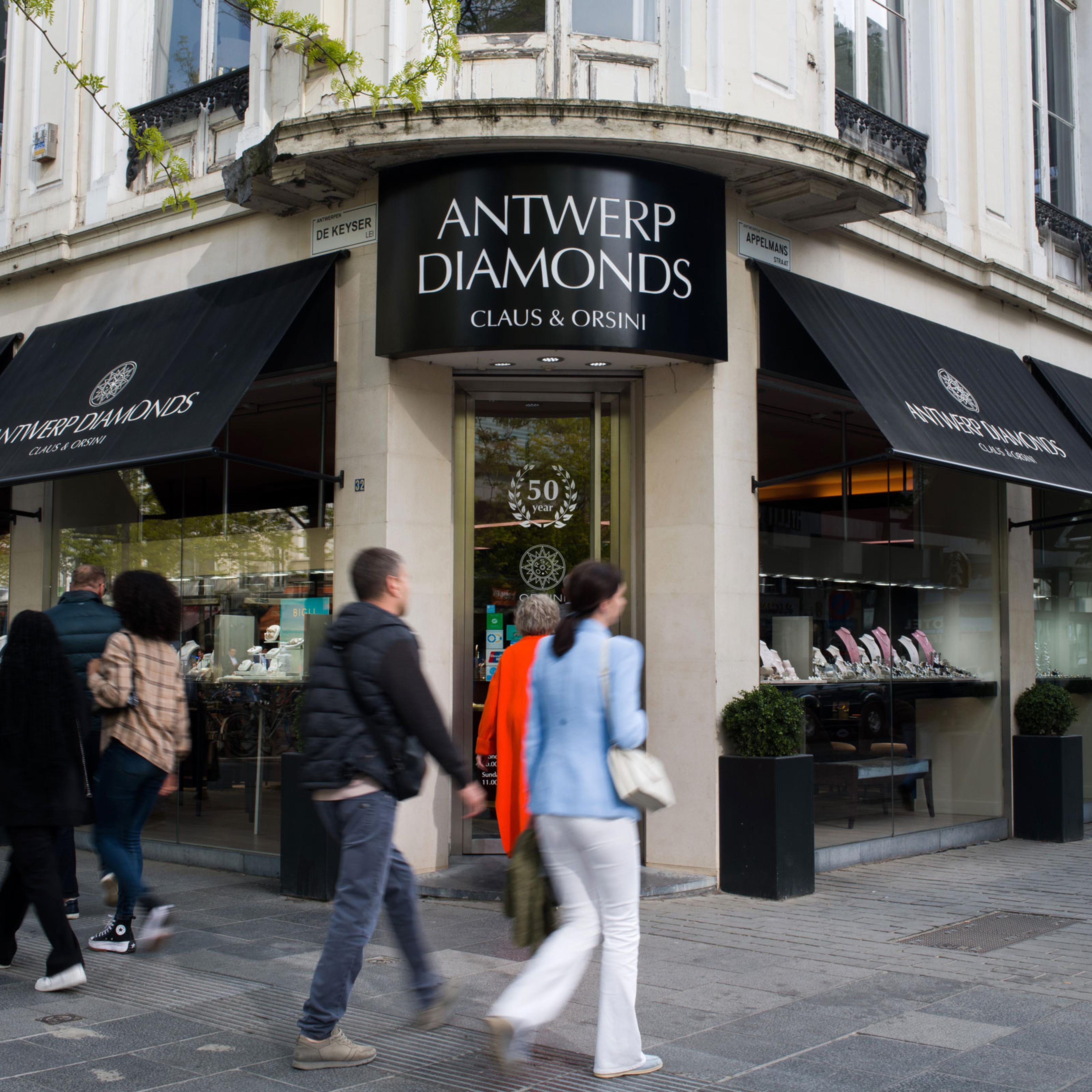 Pedestrians pass window shoppers browsing the Orsini Diamonds store in the Diamond Quarter of Antwerp