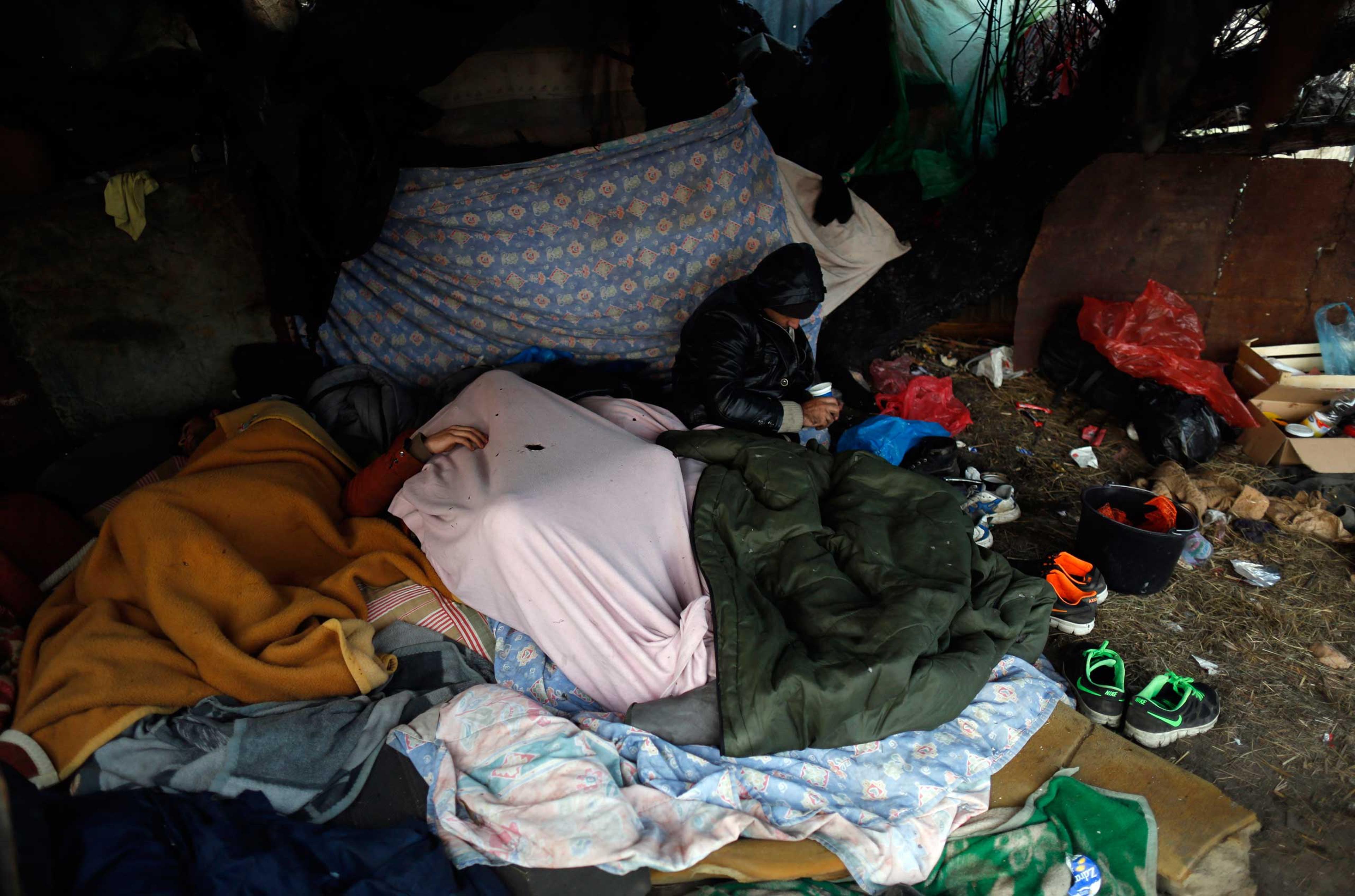 Migrants rest in the makeshift camp near the abandoned brick factory in the northern Serbian town of Subotica, near the border between Serbia and Hungary, on Dec. 15, 2014,