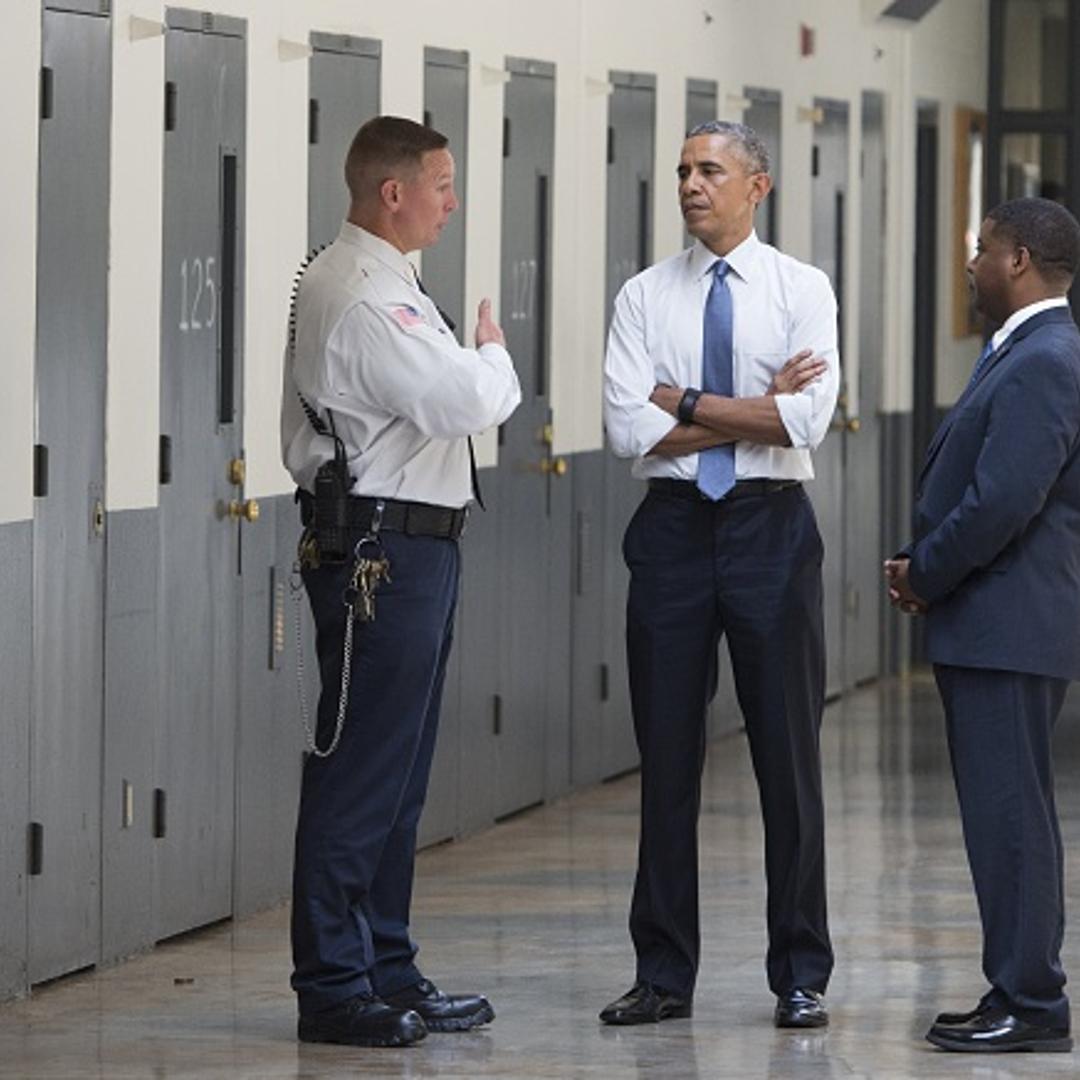 President Barack Obama, alongside Charles Samuels (R), Bureau of Prisons Director, and Ronald Warlick (L), a correctional officer, tours a cell block at the El Reno Federal Correctional Institution in El Reno, Oklahoma, on July 16, 2015.