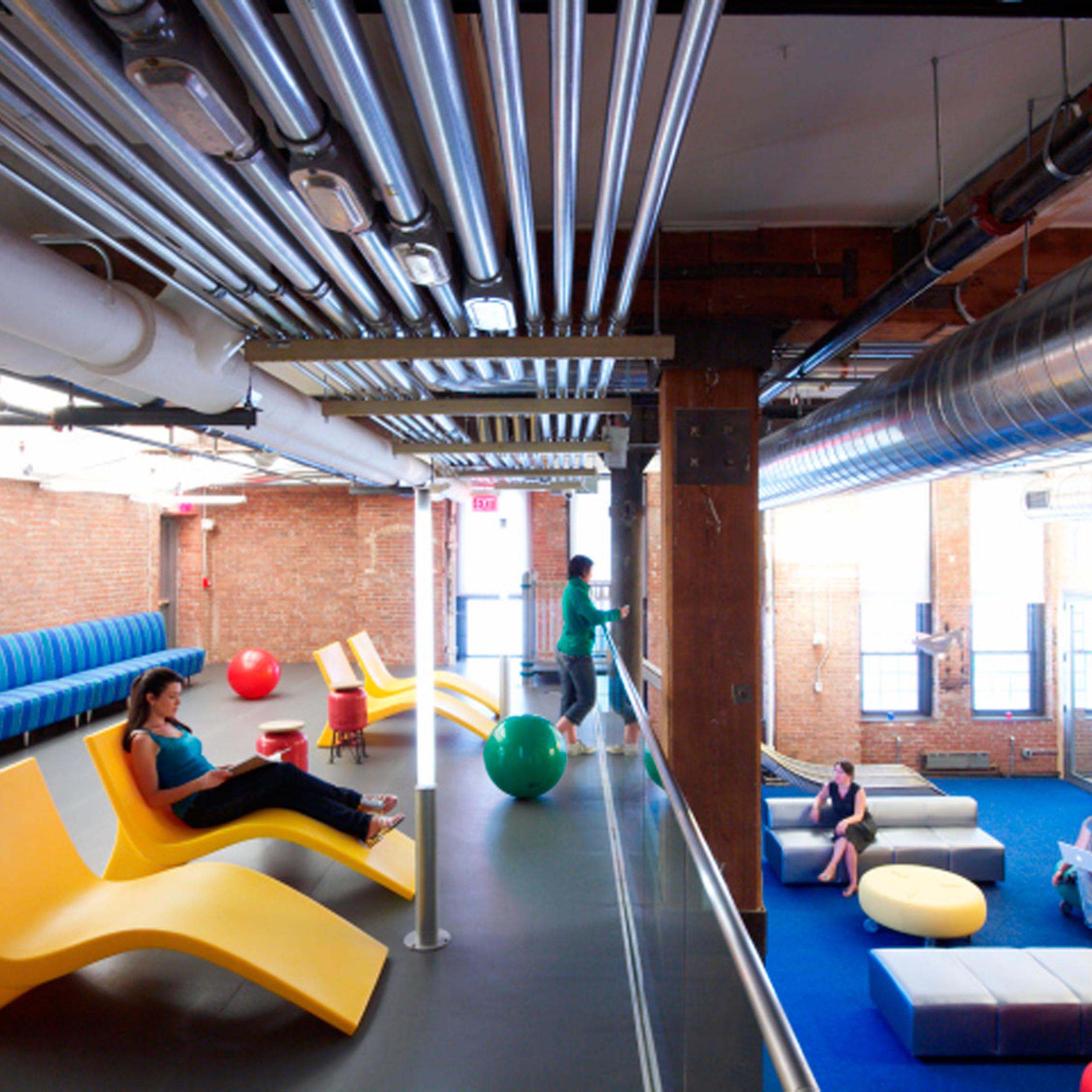 A lounge and workspace in Google's Chelsea Market office where employees can get together for a meeting or relax on a lounge chair.