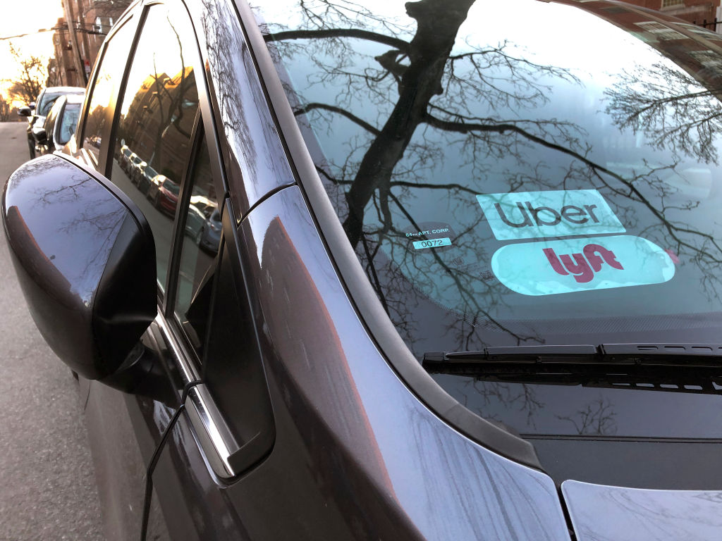 Uber and Lyft sign in windshield of car, Queens, New York