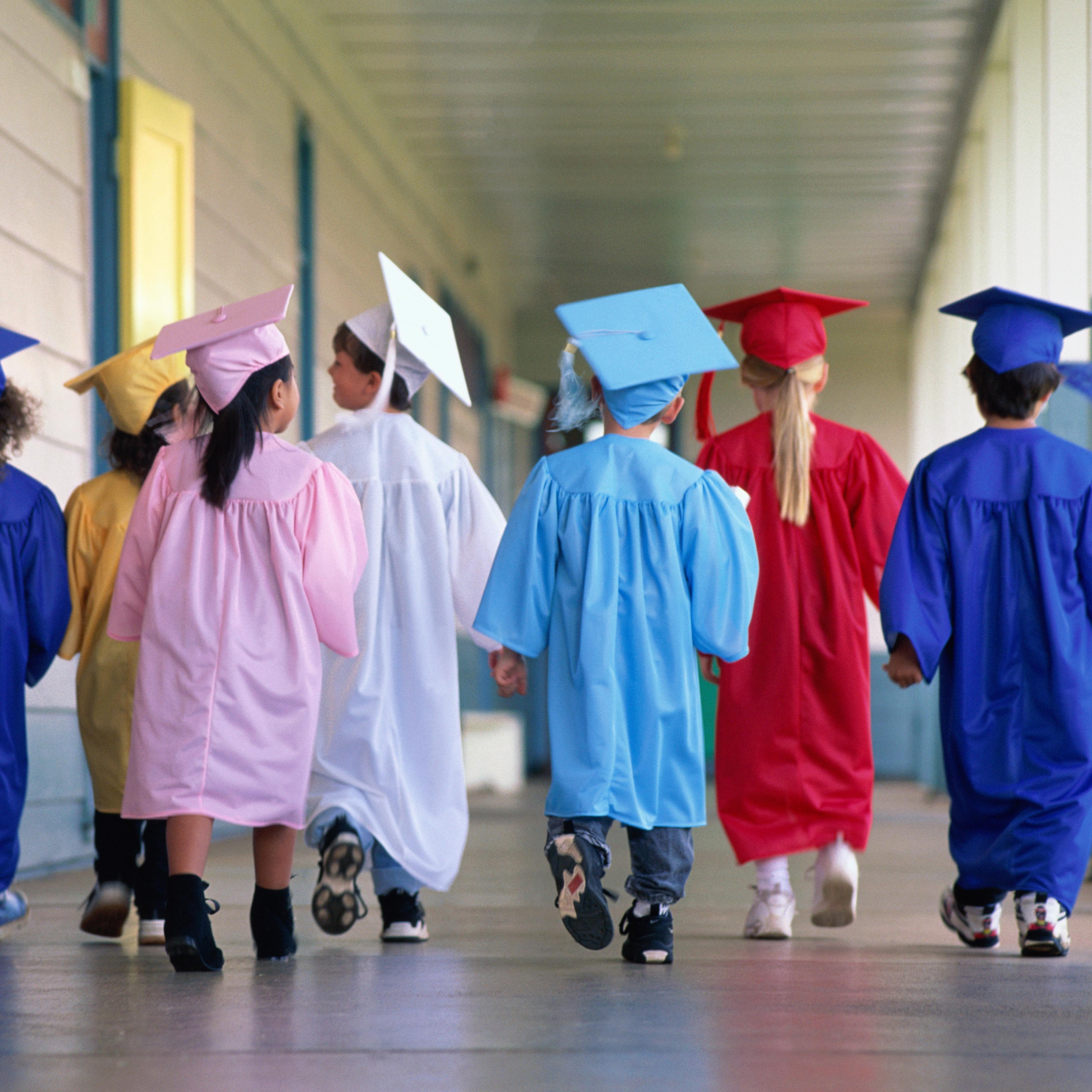 Group of children wearing graduation robes, rear view