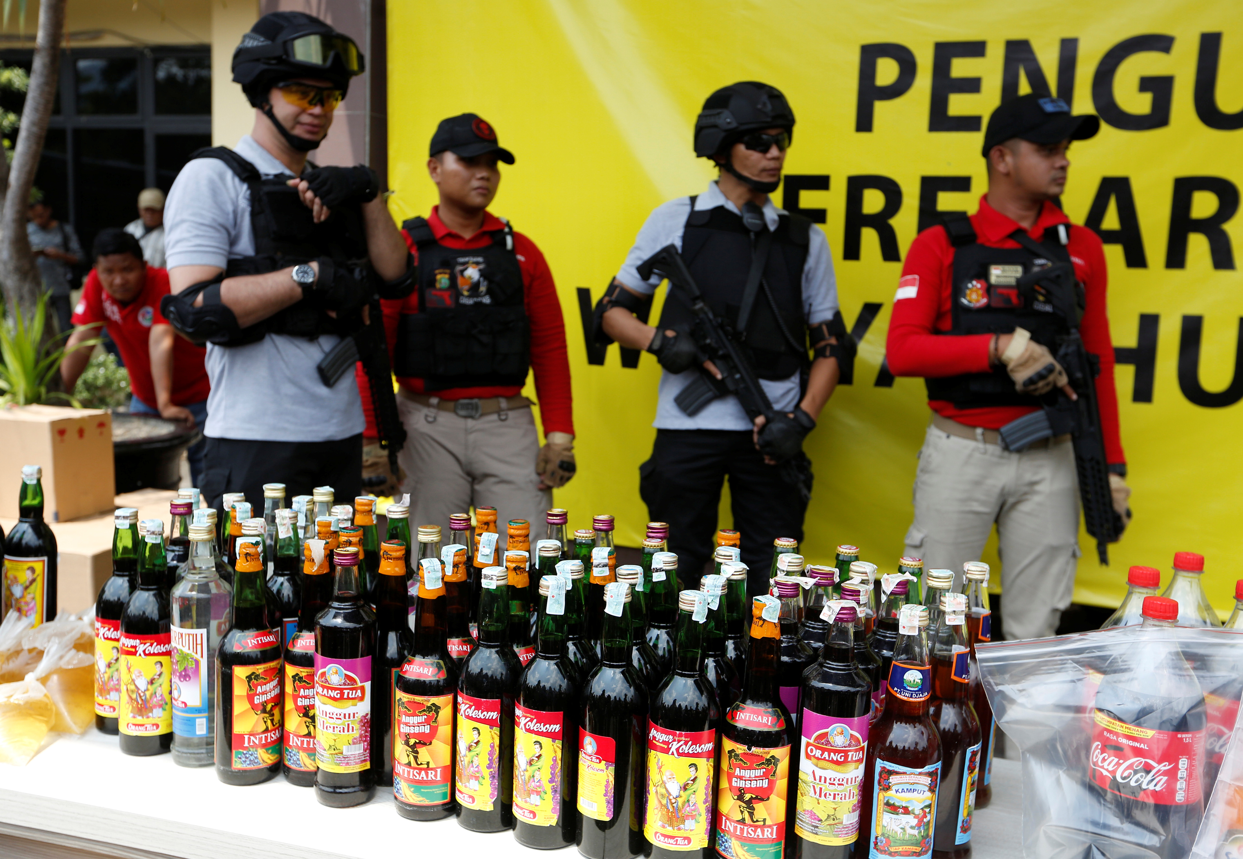 Police prepare evidence during a  press conference regarding the arrests of suspects linked to the production and sale of illegal bootleg alcohol which claimed the lives of more than 80 people this week in Jakarta