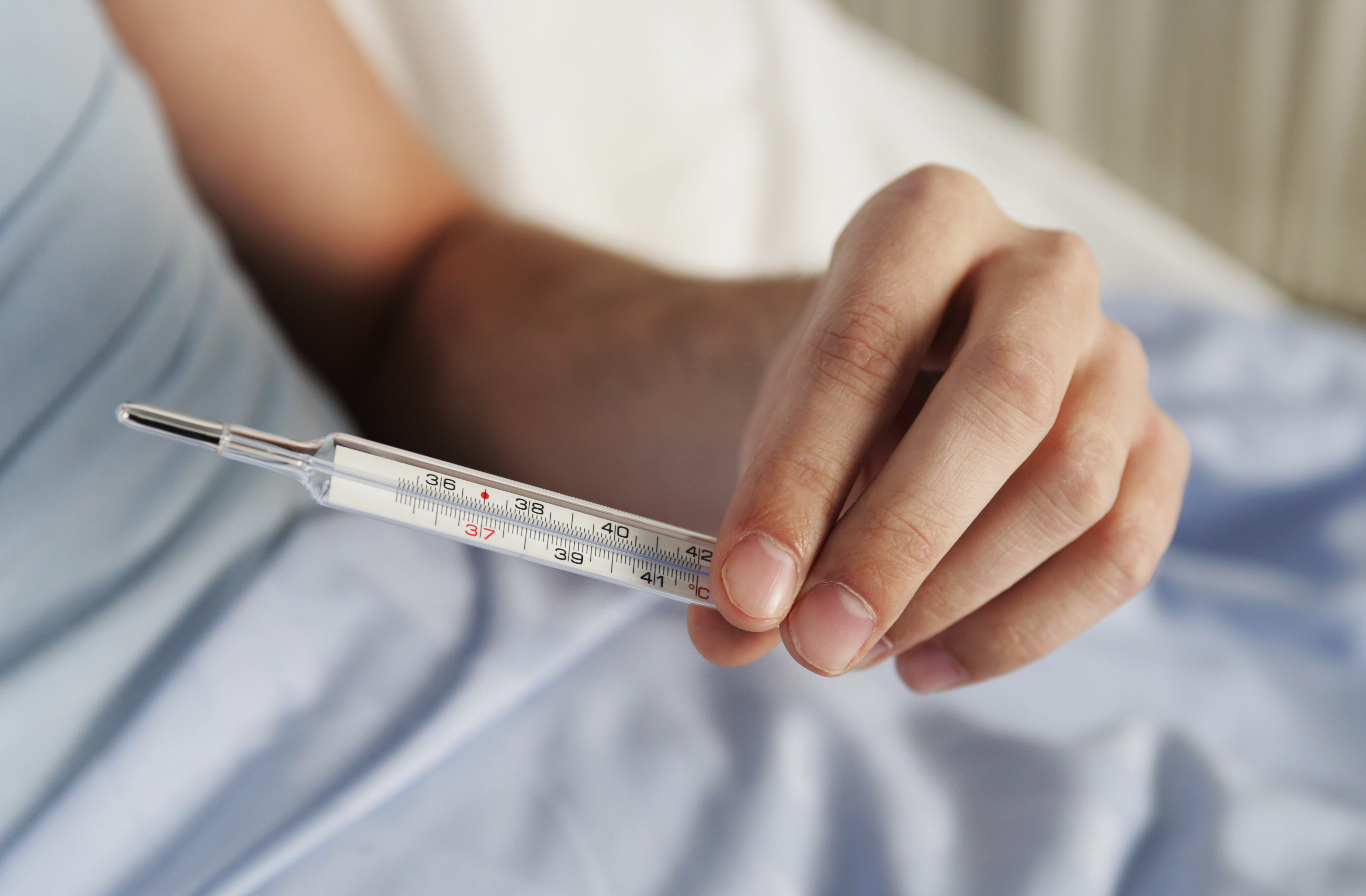 A patient checking a thermometer