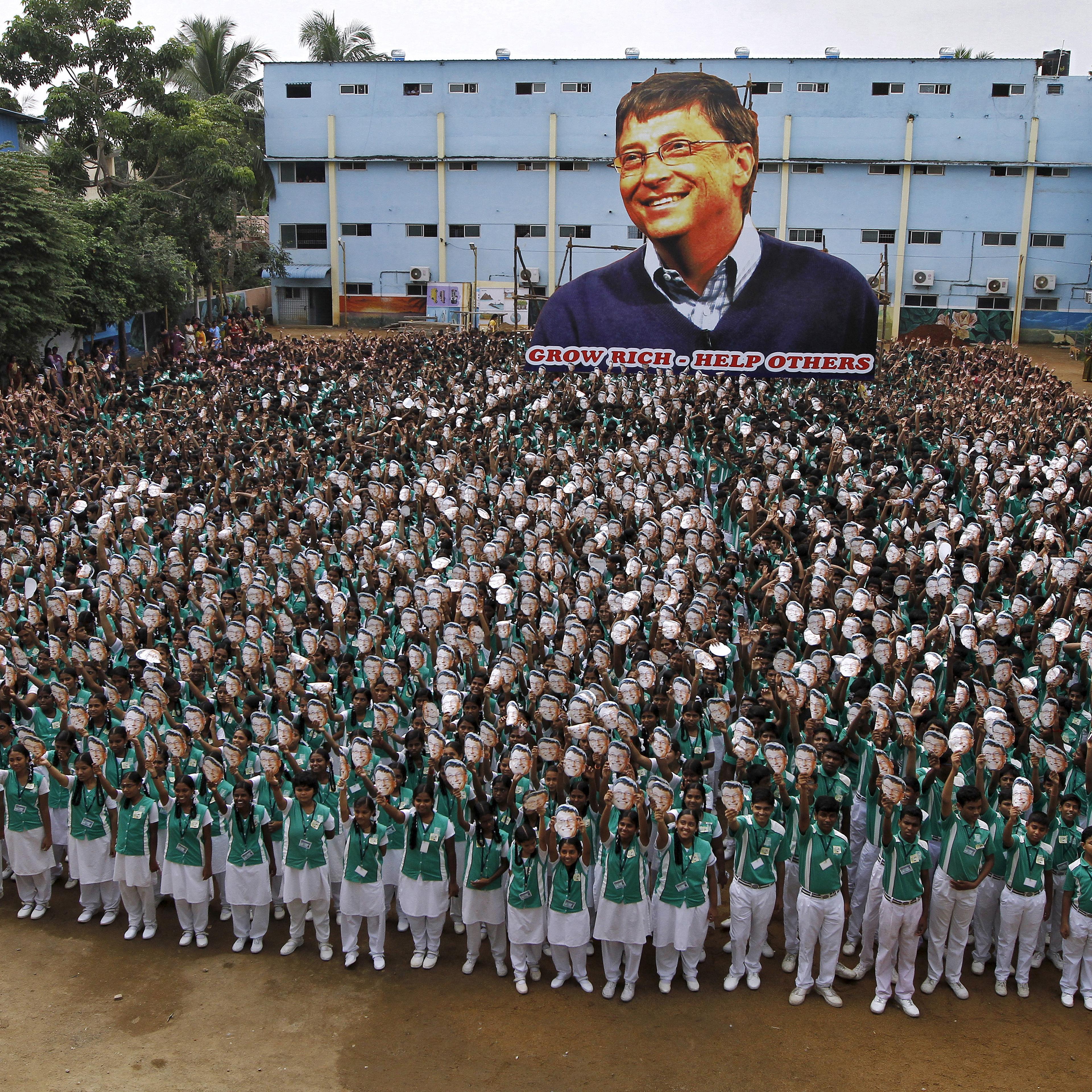 School children hold portraits of Microsoft co-founder Bill Gates in front of a giant picture of Gates during celebrations to mark his 60th birthday inside the school premises in Chennai, India on Oct. 28, 2015.