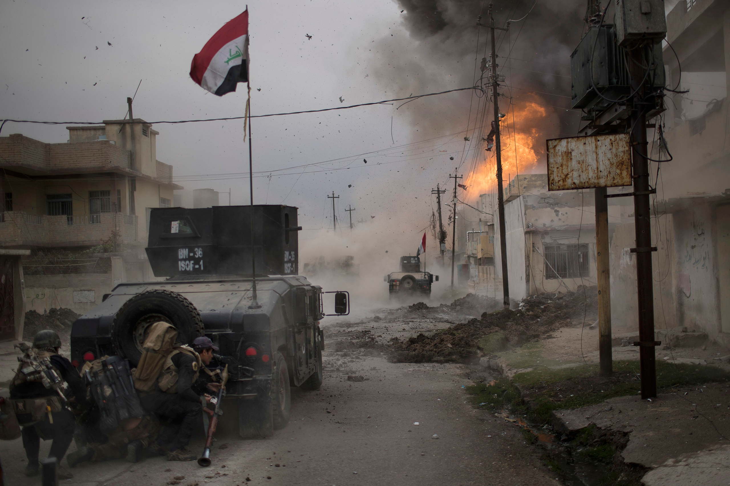 A car bomb explodes next to armored vehicles belonging to Iraqi Special Forces as they advance toward ISIS-held territory in Mosul on Nov. 16, 2016. Troops have established a foothold in the city's east from where they are driving northward into the Tahr