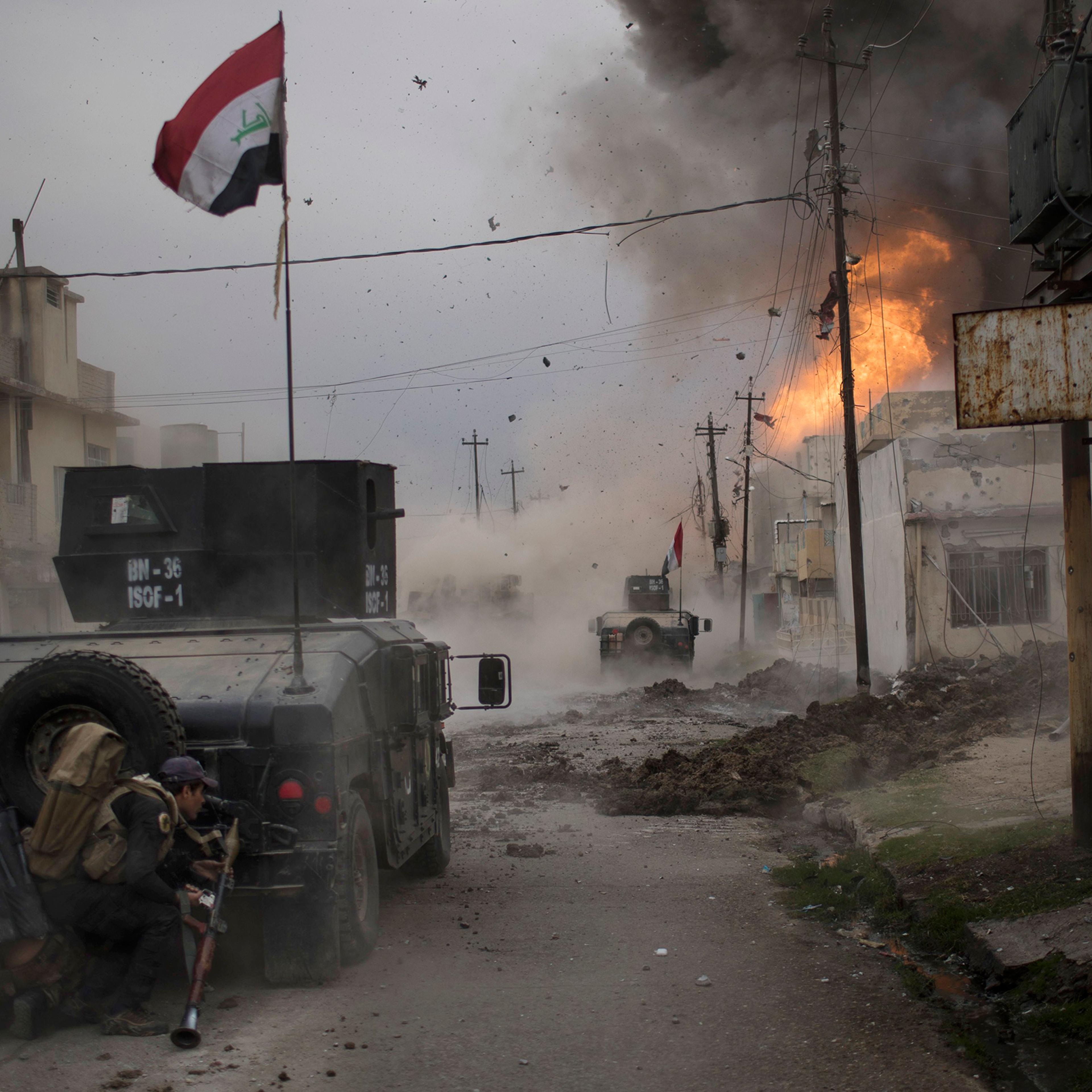 A car bomb explodes next to armored vehicles belonging to Iraqi Special Forces as they advance toward ISIS-held territory in Mosul on Nov. 16, 2016. Troops have established a foothold in the city's east from where they are driving northward into the Tahr