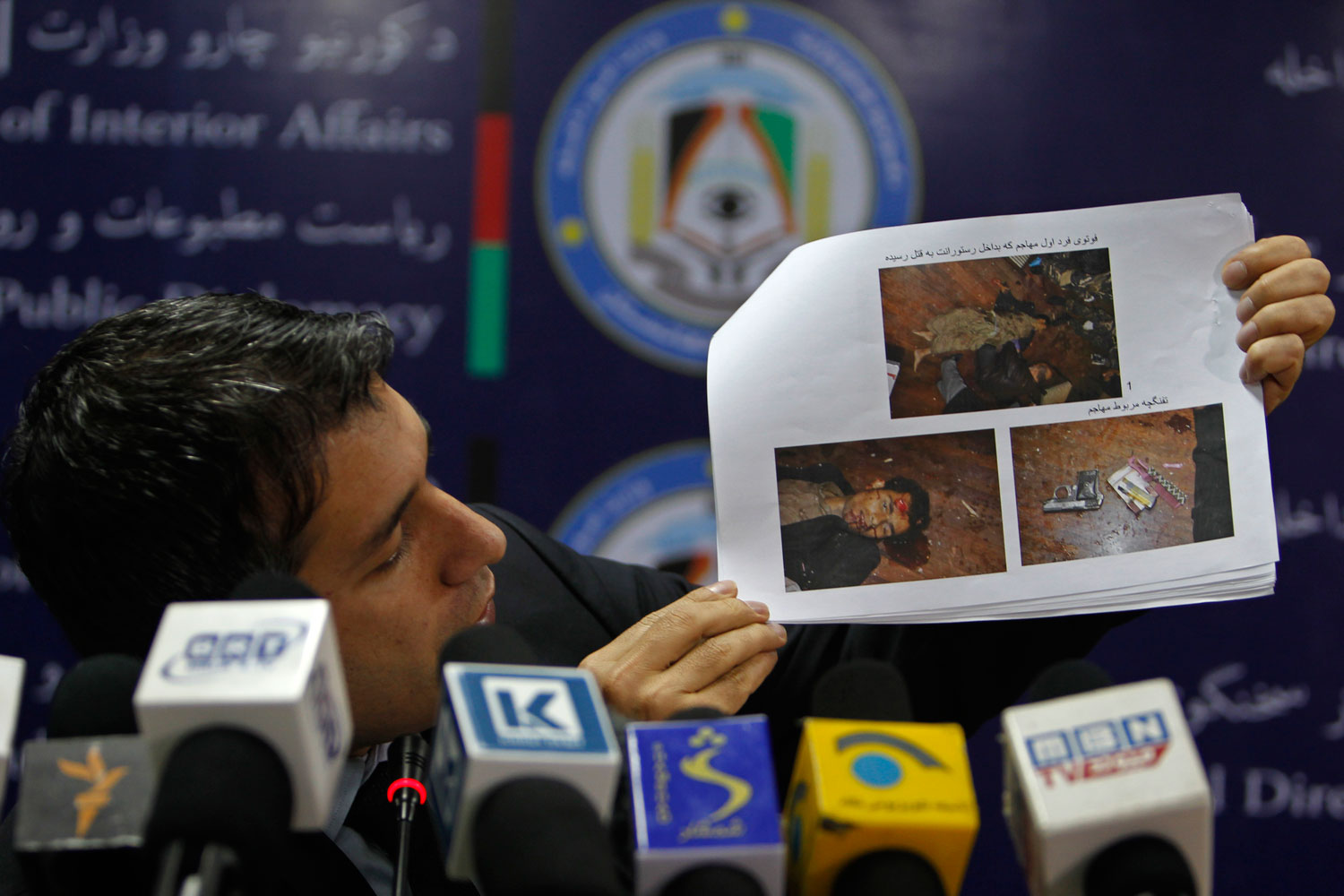 Afghanistan's interior ministry spokesman Sediq Sediqqi shows pictures of Taliban insurgents that were killed last night in a luxury hotel in Kabul March 21, 2014.