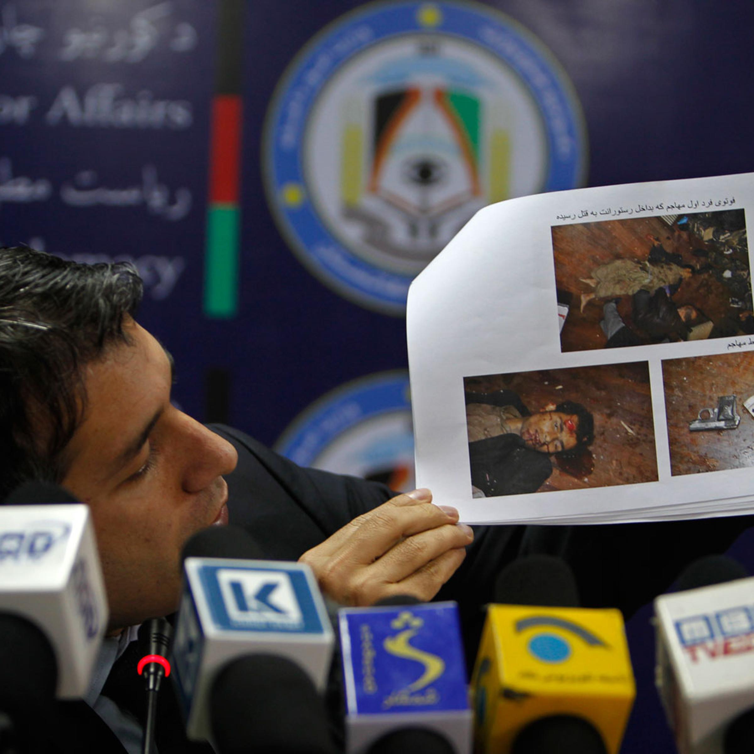 Afghanistan's interior ministry spokesman Sediq Sediqqi shows pictures of Taliban insurgents that were killed last night in a luxury hotel in Kabul March 21, 2014.