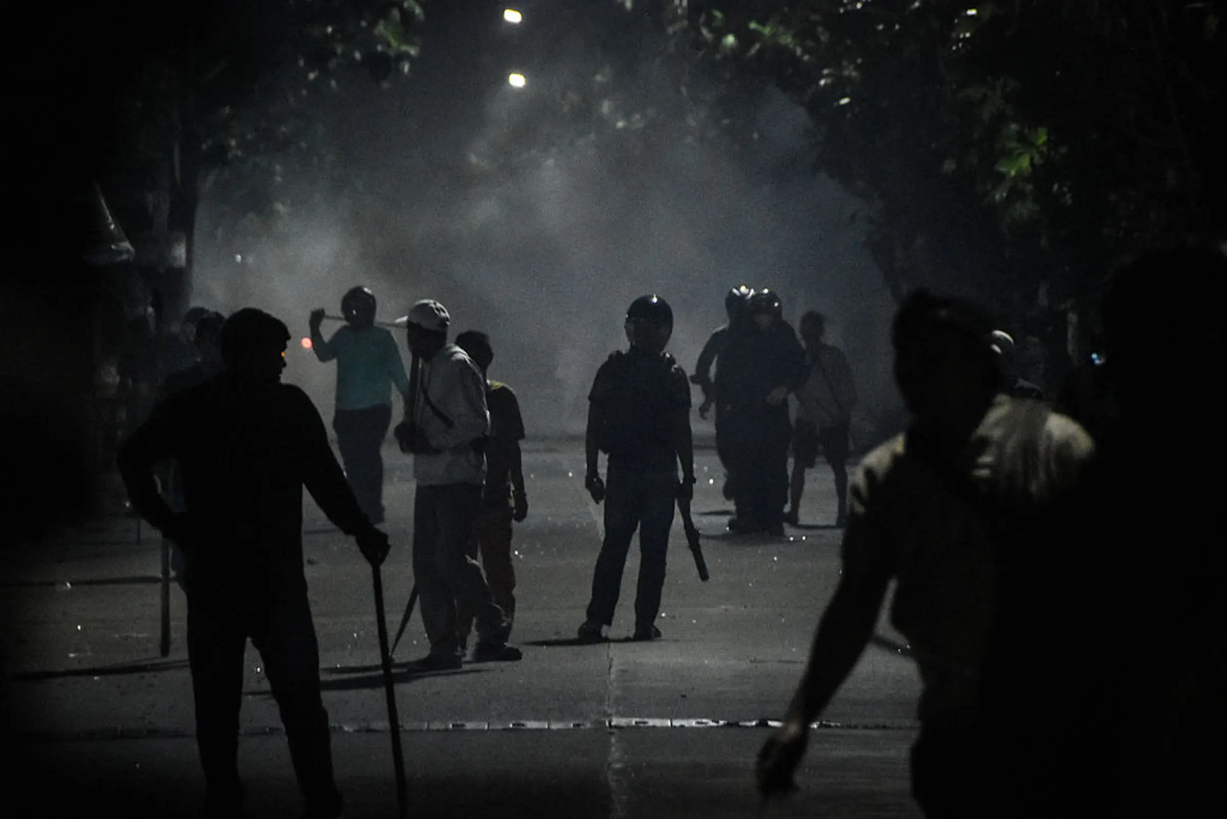 Plainclothes police officers hold sticks as they disperse protesters in front of the Bekasi Metro Police headquarters in Bekasi, West Java on Sept. 1, 2025.