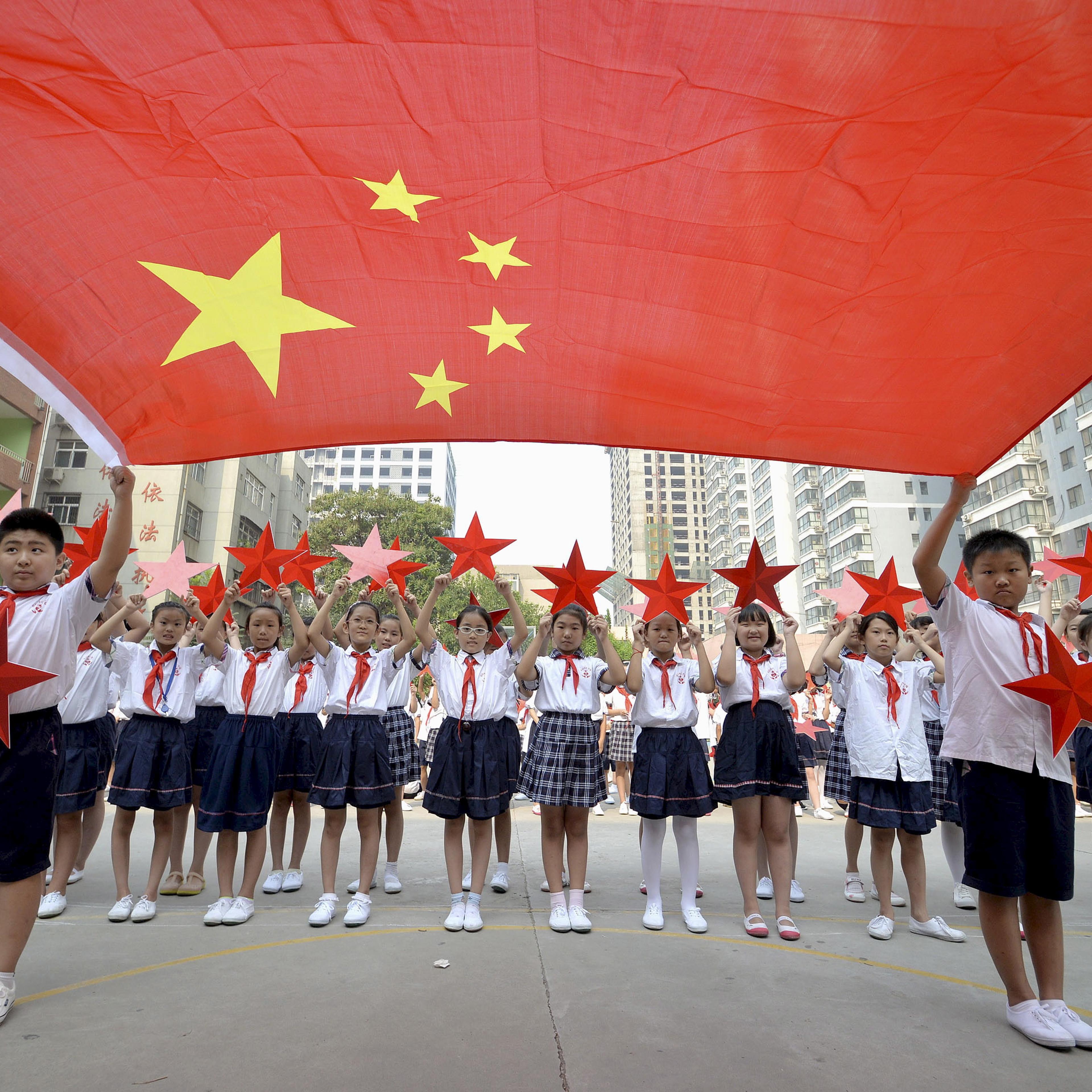 Students pose with a Chinese national flag and red stars during a event to mark the 70th anniversary of the Victory of Chinese People's War of Resistance Against Japanese Aggression and the World Anti-Fascist War, at a primary school in Handan