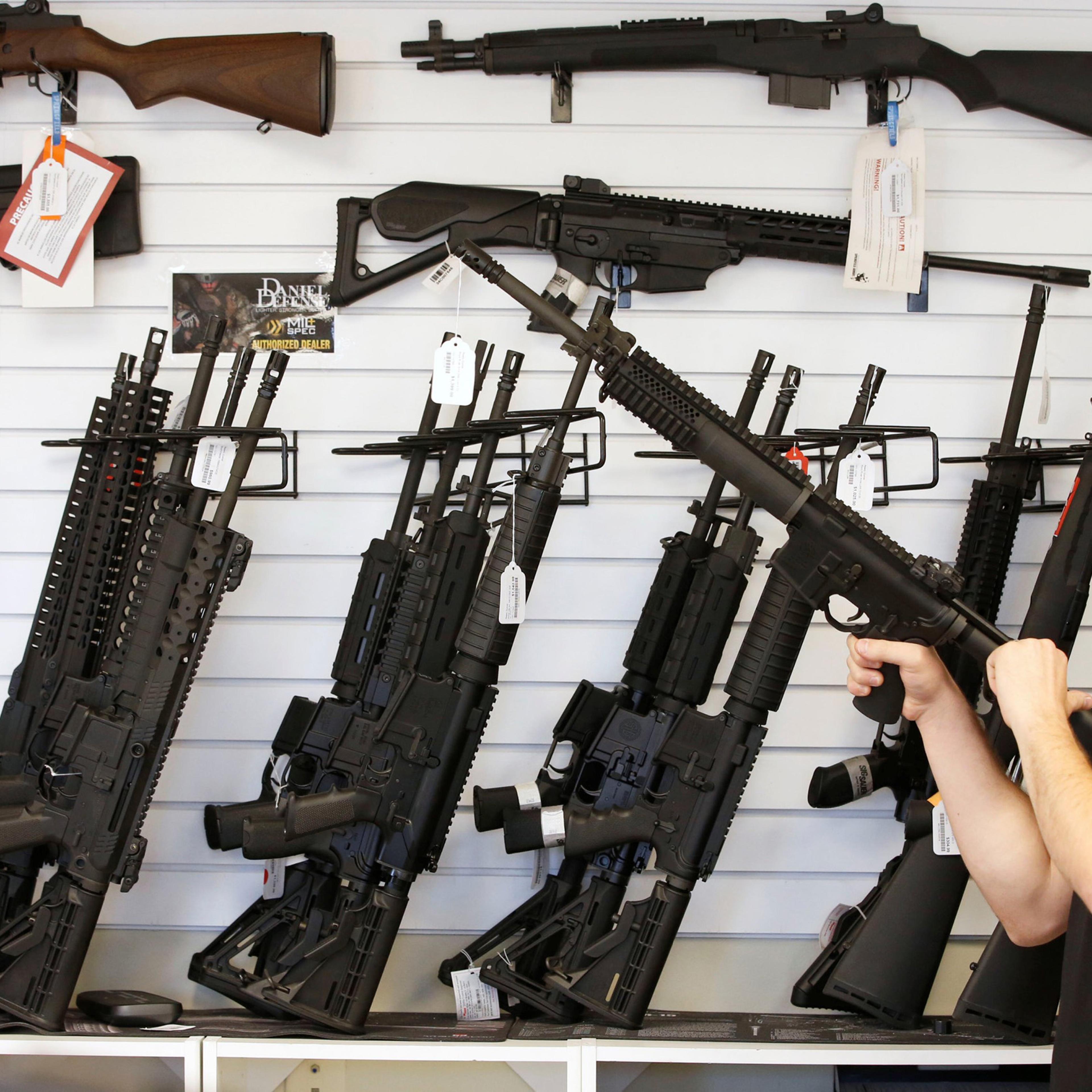 A salesman clears the chamber of an AR-15 at the "Ready Gunner" gun store in Provo, Utah on June 21, 2016.