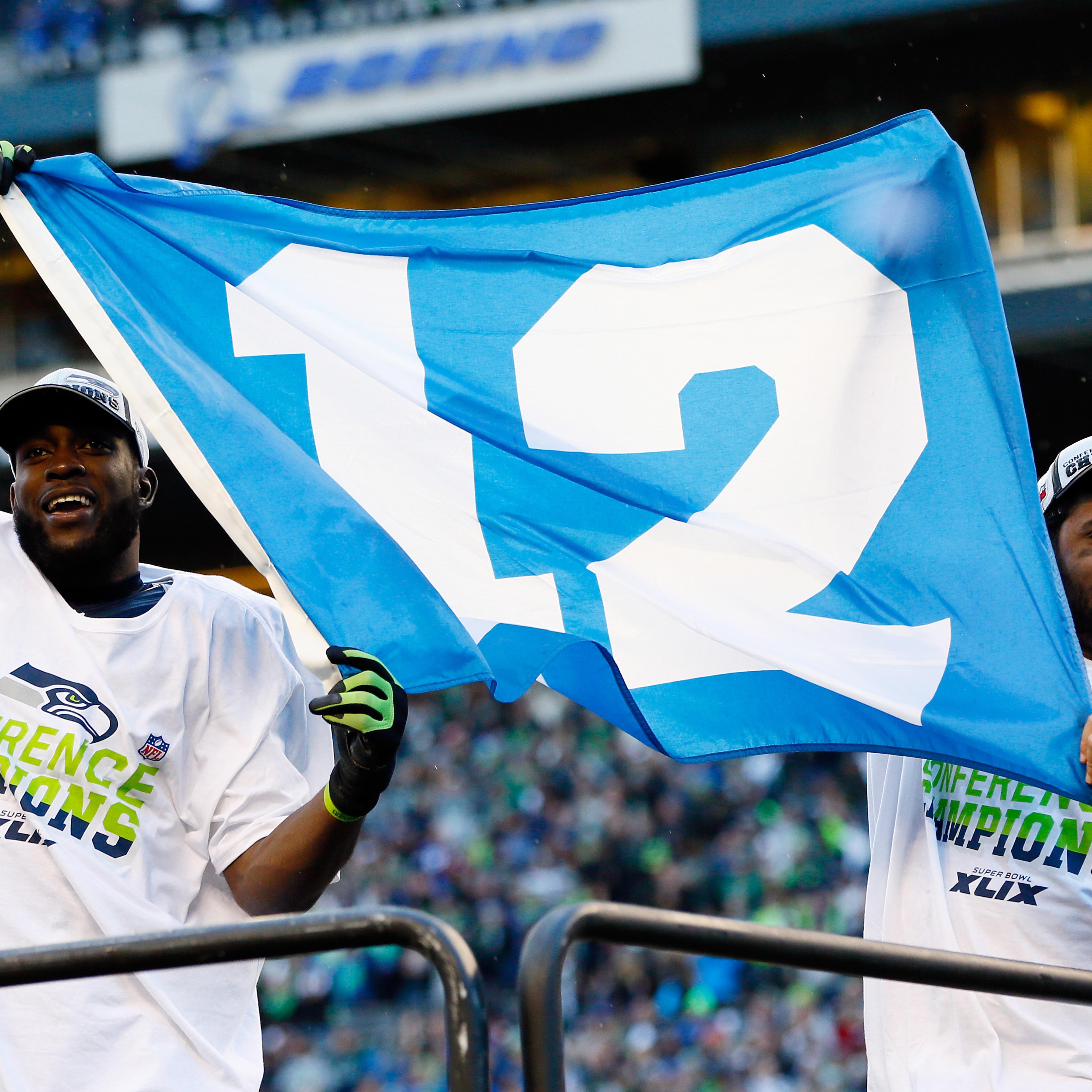 Kam Chancellor (L) and Russell Wilson #3 of the Seattle Seahawks celebrate with a 12th Man flag after defeating the Green Bay Packers in the 2015 NFC Championship game at CenturyLink Field on Jan. 18, 2015 in Seattle, Wash.