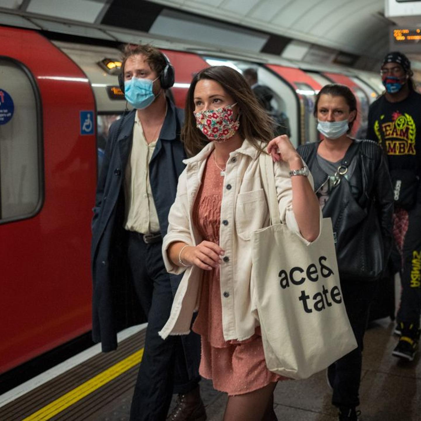 Commuters wearing protective face coverings travel on Victoria line at rush hour in central London