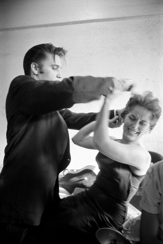 June 30, 1956. Backstage at the Mosque Theatre, Richmond, Virginia. Elvis didn't like his women with corsets or hairspray — he was more into the natural look. Here he is messing up Bobbi Owen's hair, trying to annoy her in a cute way but she took it so seriously. I wanted  something to show his character and to show he could be playful and that he liked messing around. With Elvis, you never knew what or where he was coming from. He was so spontaneous, you had to be ready, otherwise you'd miss it. That was the fun of it.