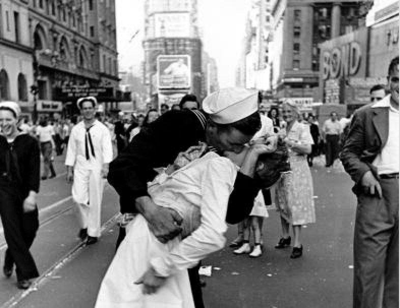 Happy sailor kissing nurse in Times Square during impromptu V-J Day celebration following announcement of the Japanese surrender and the end of WWII.