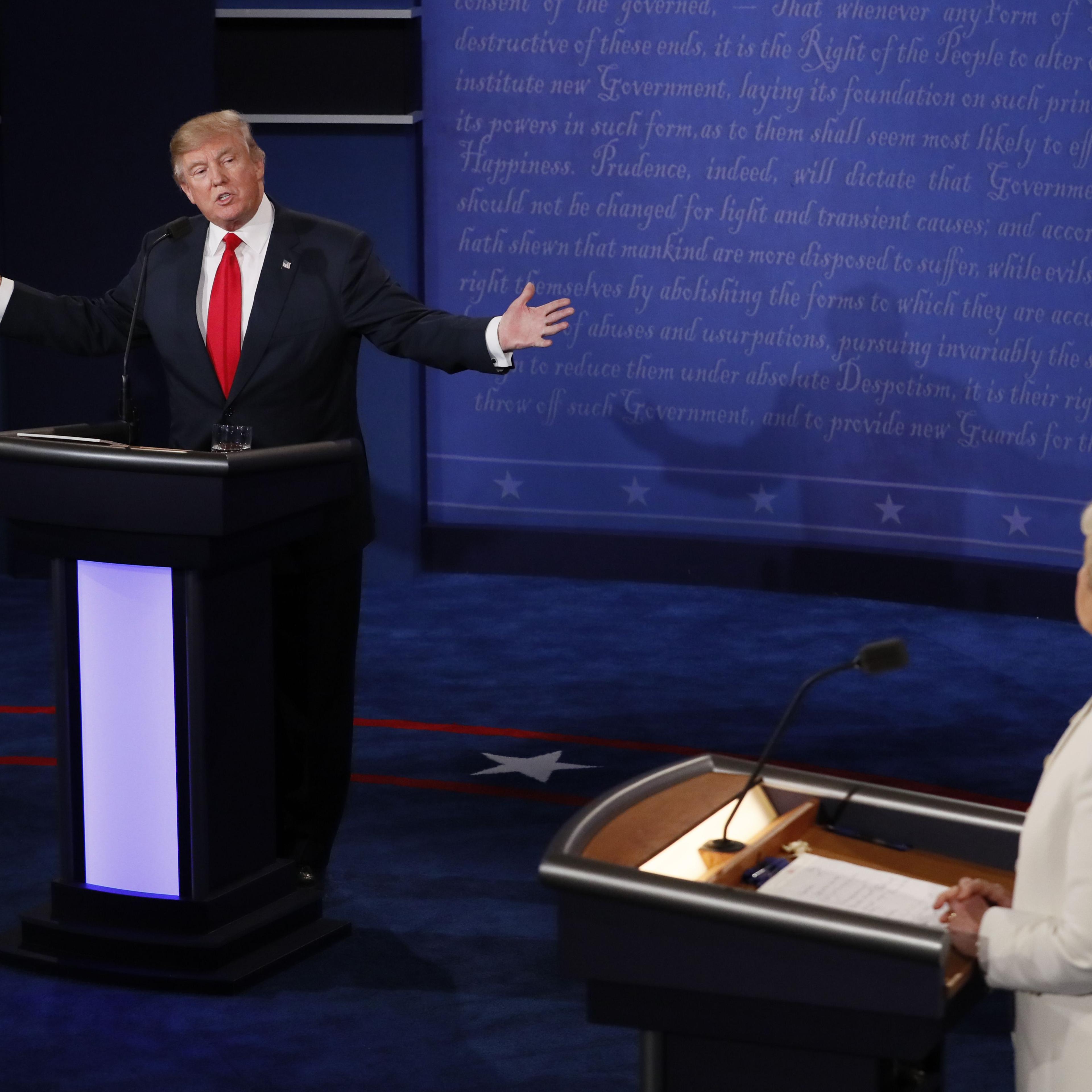 Republican presidential nominee Donald Trump speaks as Democratic presidential nominee Hillary Clinton (R) looks on during the final presidential debate at the Thomas & Mack Center on the campus of the University of Las Vegas in Las Vegas on Oct. 19, 201
