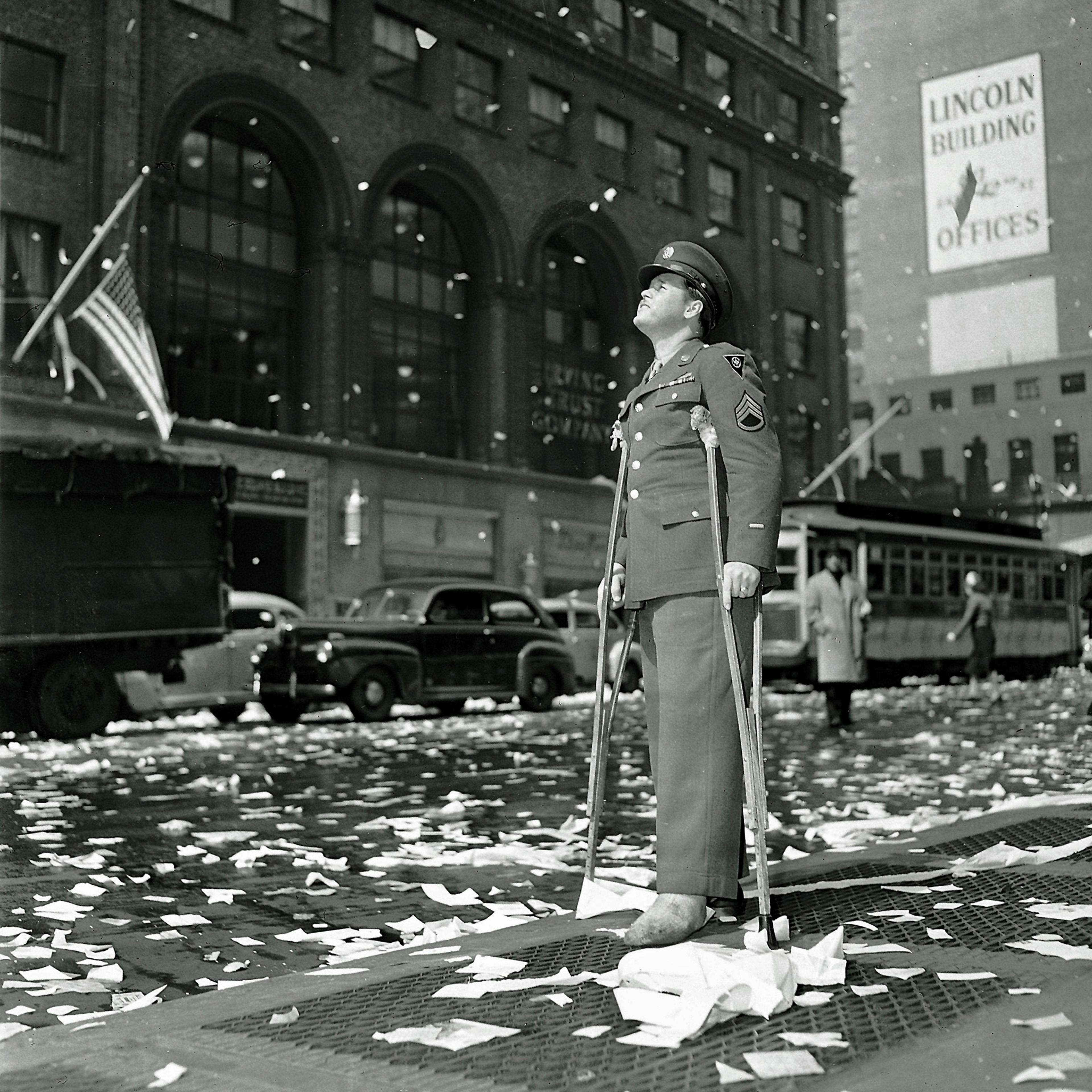 Staff Sgt. Arthur Moore of Buffalo, N.Y., who was wounded in Belgium, stands on 42nd Street near Grand Central Station in New York Monday, May 7, 1945 as New Yorkers celebrate news of VE Day, victory over Nazi Germany.