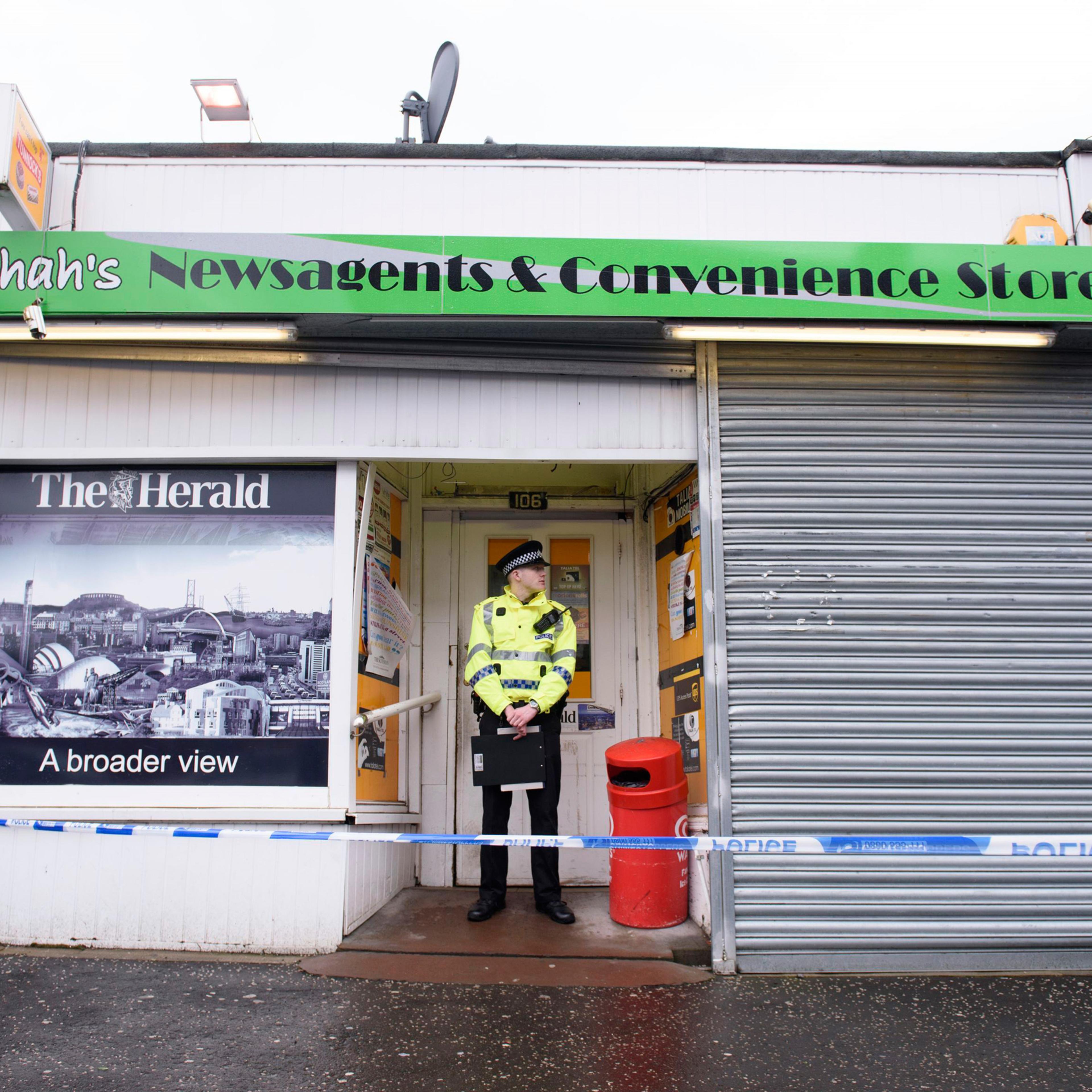 A police officer stands outside the shop where Asad Shah worked in Glasgow, Saturday March 26, 2016. Scottish police say the killing of a Muslim shopkeeper who wished Christians a happy Easter is being investigated as “religiously prejudiced.” Vigils wer