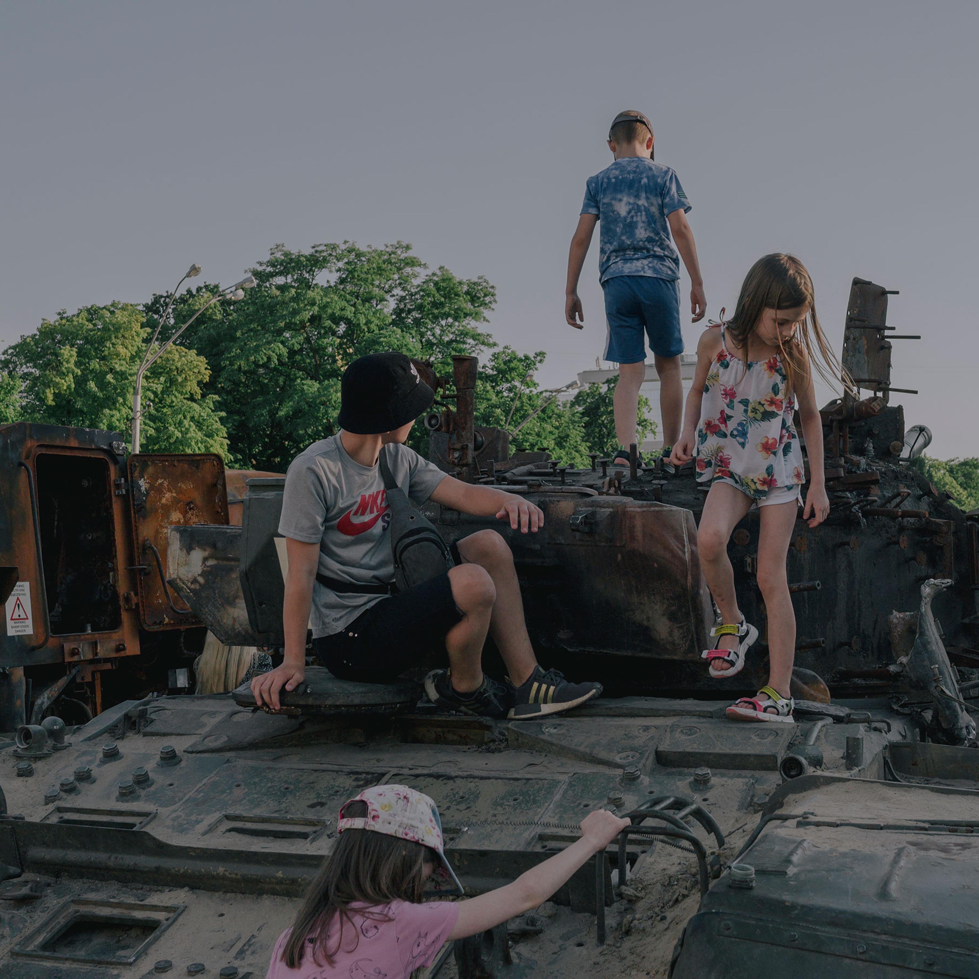 Children play on destroyed Russian war equipment in front of St. Michael‘s Monastery in Kyiv on June 12, 2022.