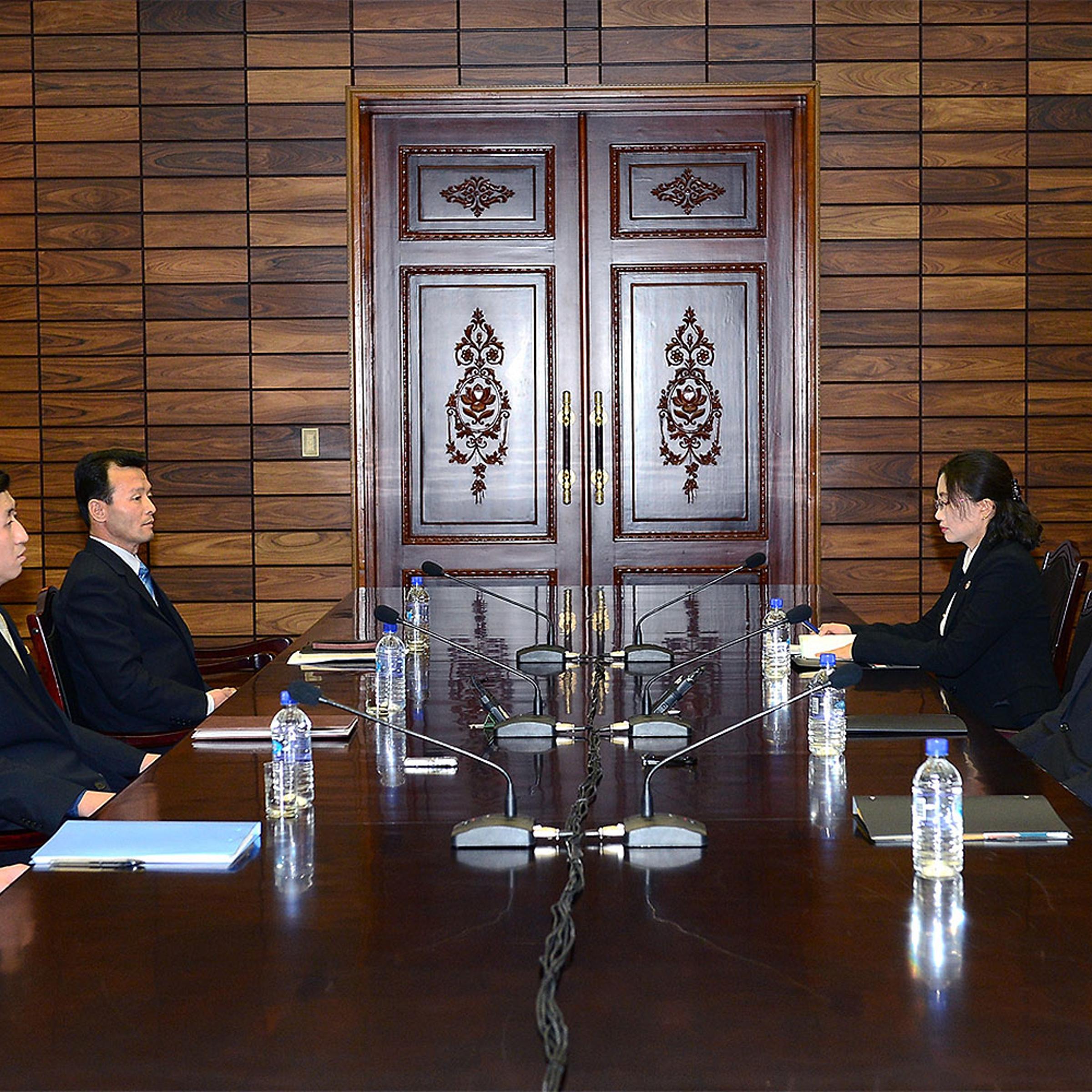 In this handout provided by South Korean Unification Ministry, Lee Duk-Haeng (R, Center), the head of South Korea's working-level delegation to family reunion talks with his North Korean counterpart Park Yong-Il (L, Center) during their meeting on Feb. 5, 2014 in Panmunjom, North Korea