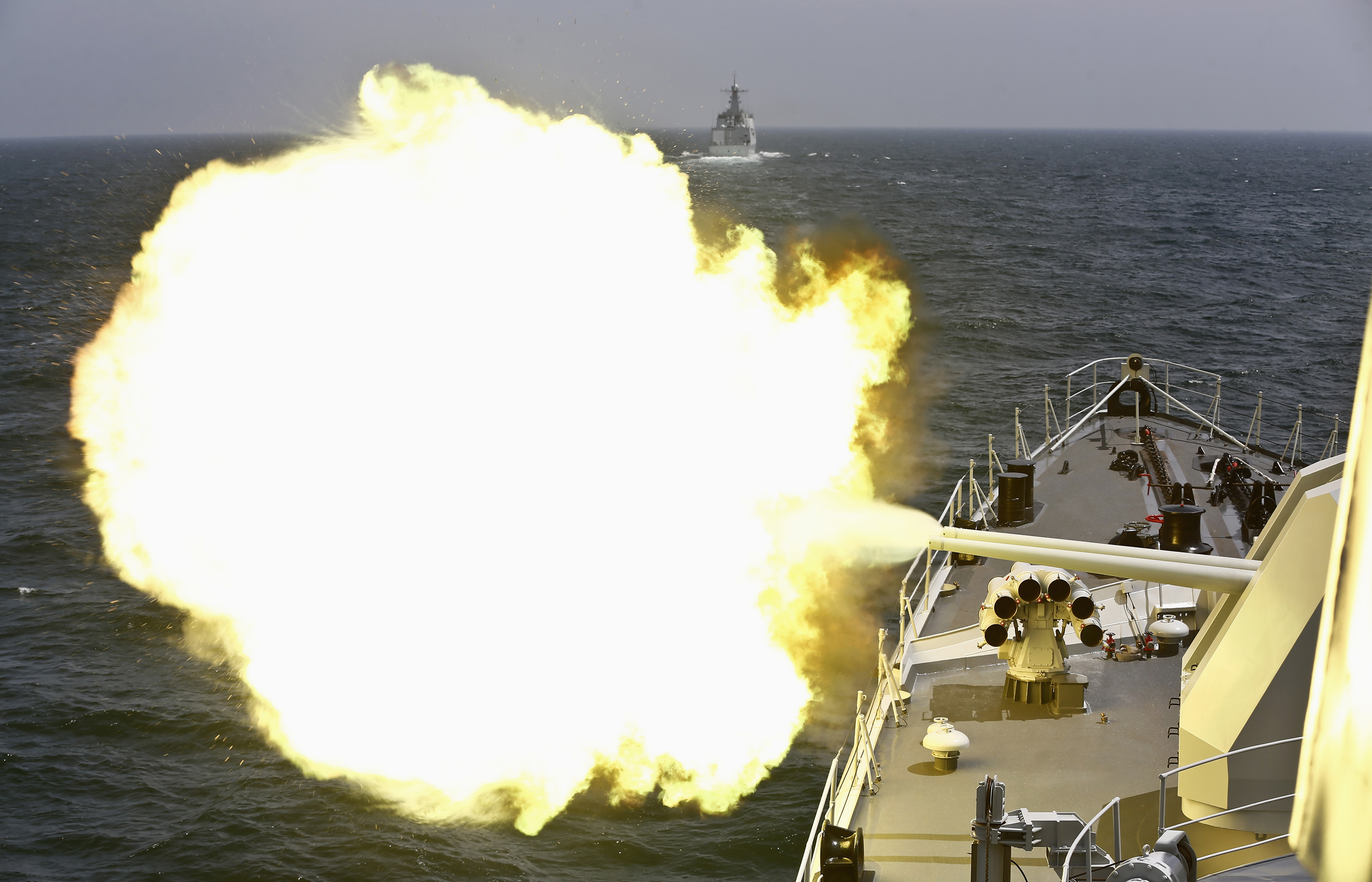 A Chinese navy vessel fires its cannon during the Joint Sea-2014 naval drill outside Shanghai on the East China Sea
