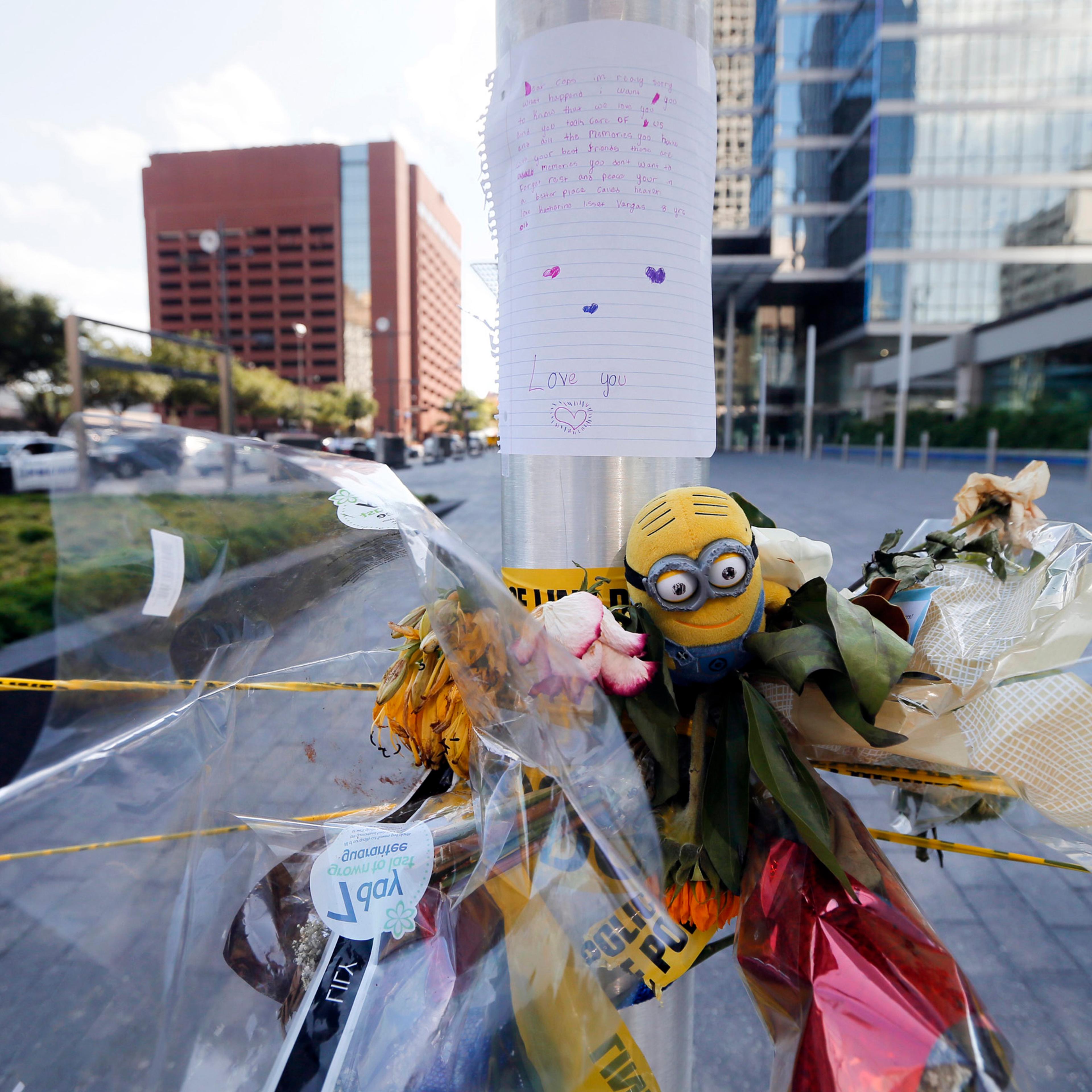 A letter from a child to Dallas police officers sits atop flowers and other items left at a makeshift memorial by the crime scene of Thursday night's shooting in Dallas on July 10, 2016.