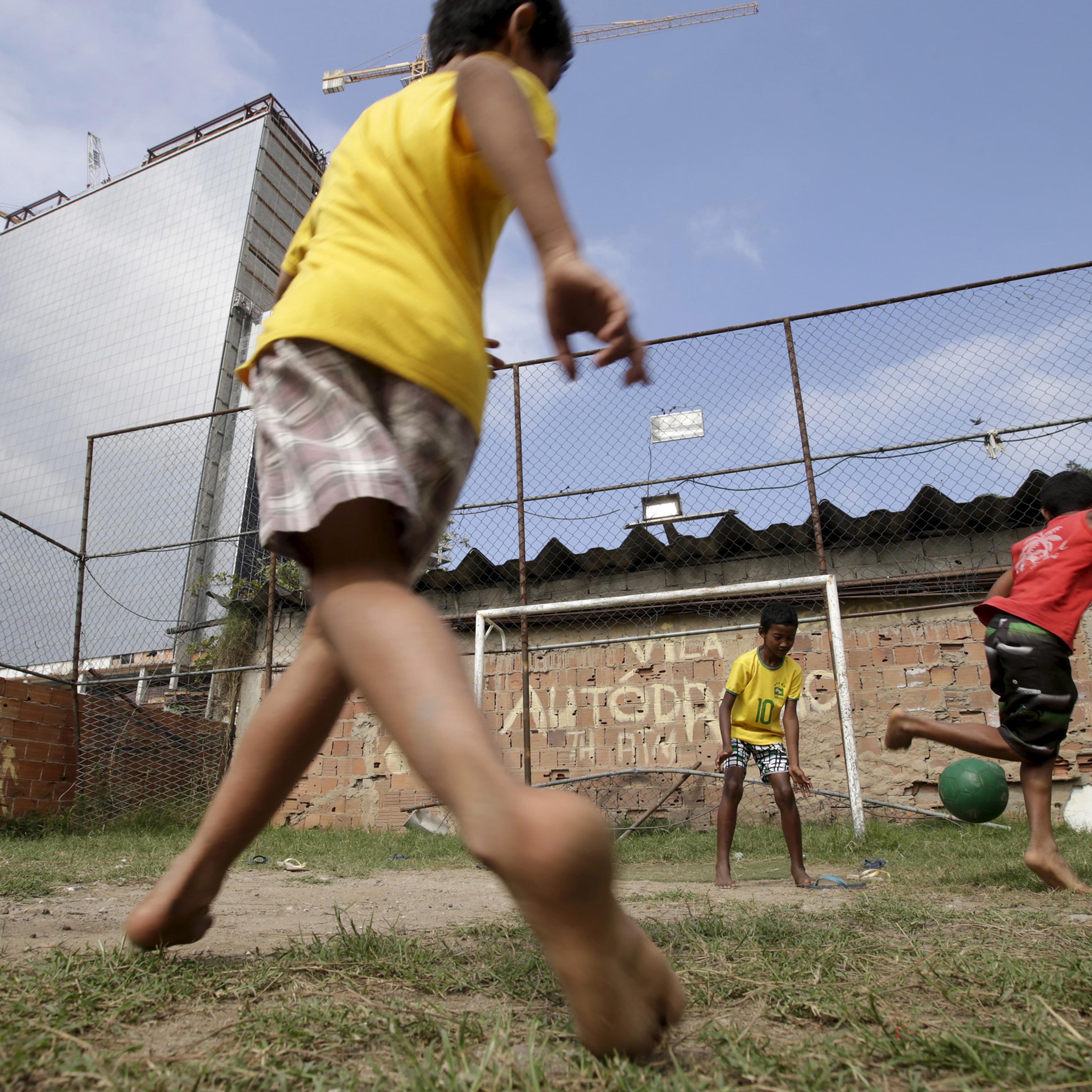 Children play soccer in the Vila Autodromo slum in Rio de Janeiro, Brazil, July 28, 2015. As sports arenas rise up around them and neighbours' houses are demolished, around 50 families remain in Vila Autodromo, a favela bordering the Olympic Park in Rio