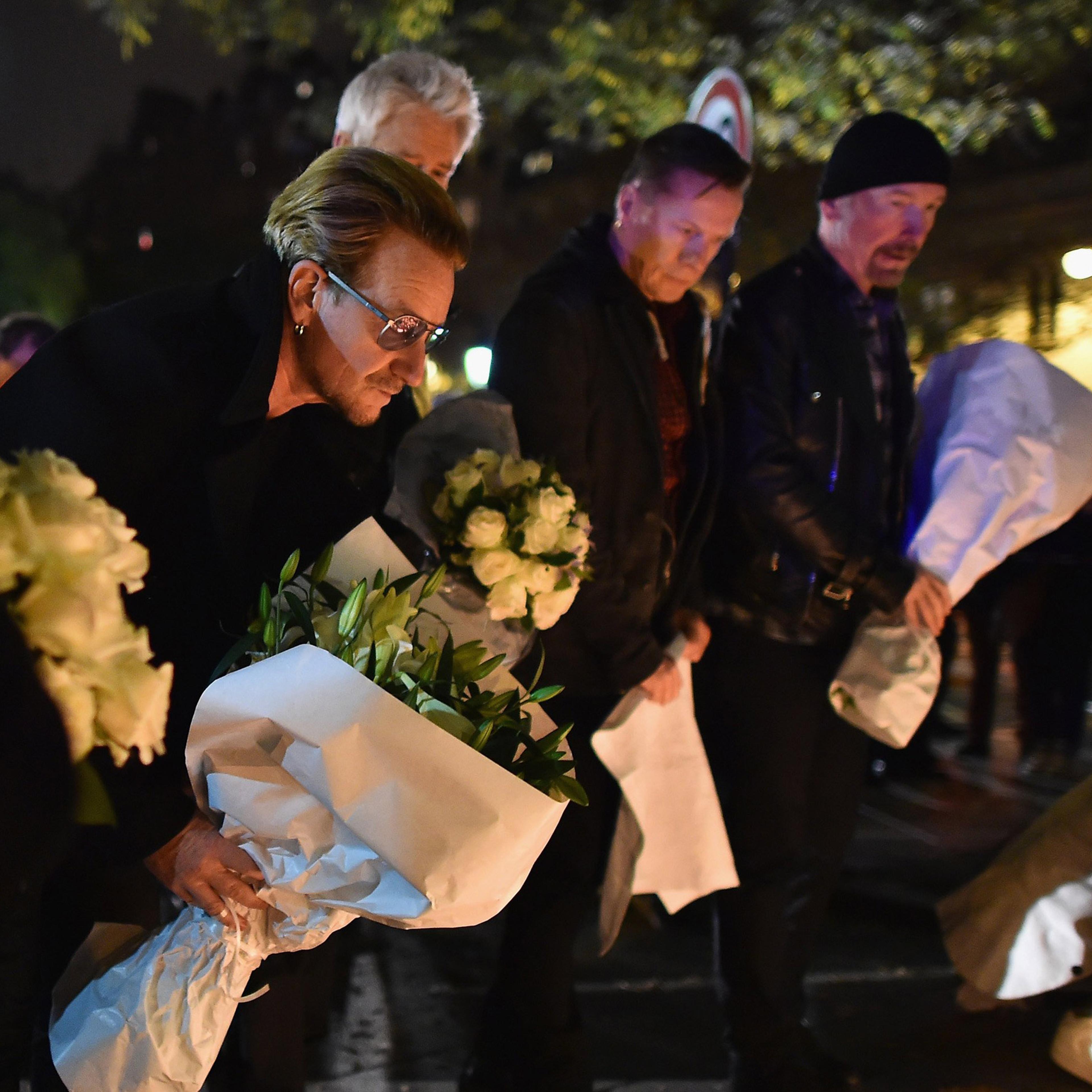 Bono and band members from the band U2 place flowers on the pavement near the scene of yesterday's Bataclan Theatre terrorist attack on Nov. 14, 2015 in Paris.