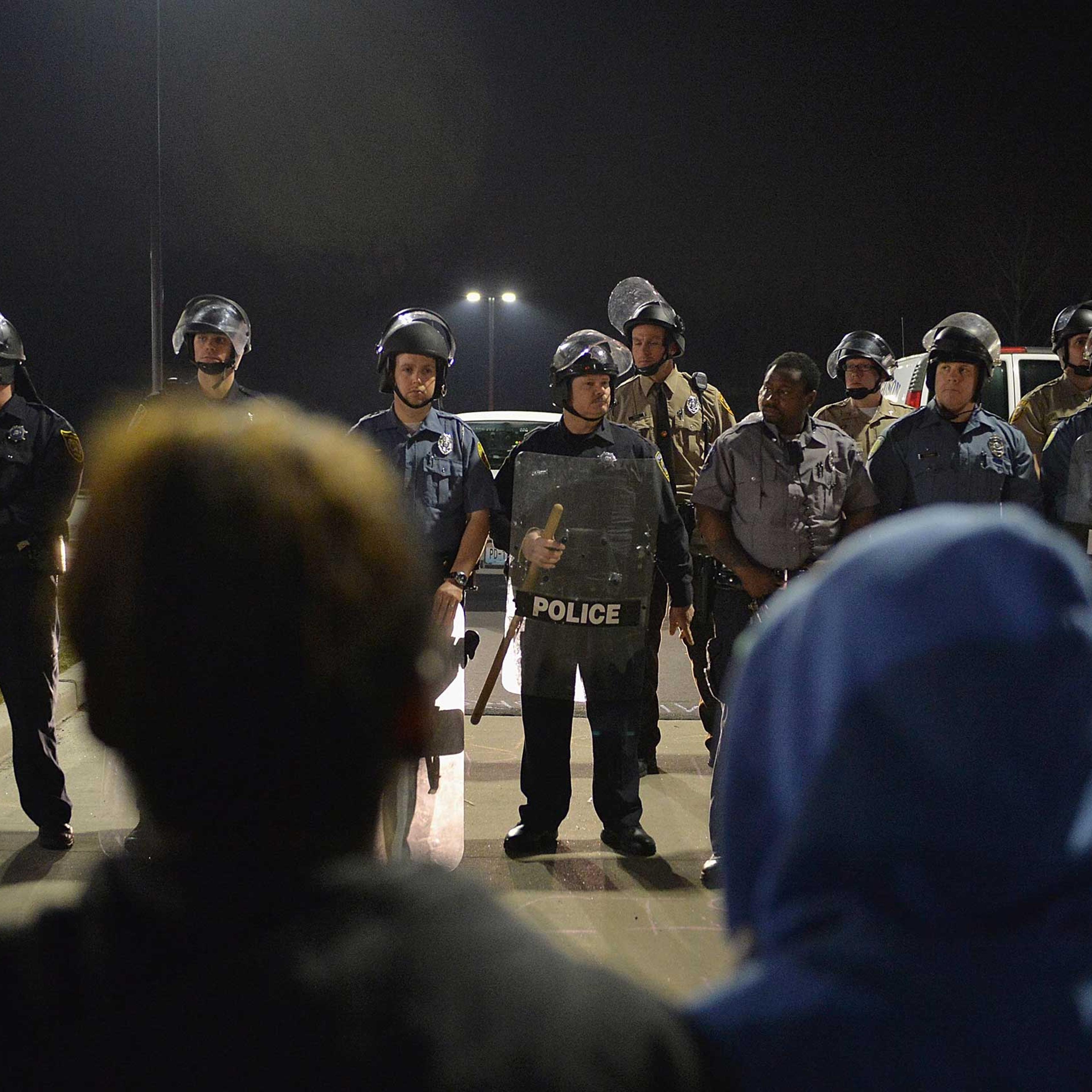 Police officers stand on alert during a protests outside the Ferguson Police Department on March 11, 2015 in Ferguson, Mo.