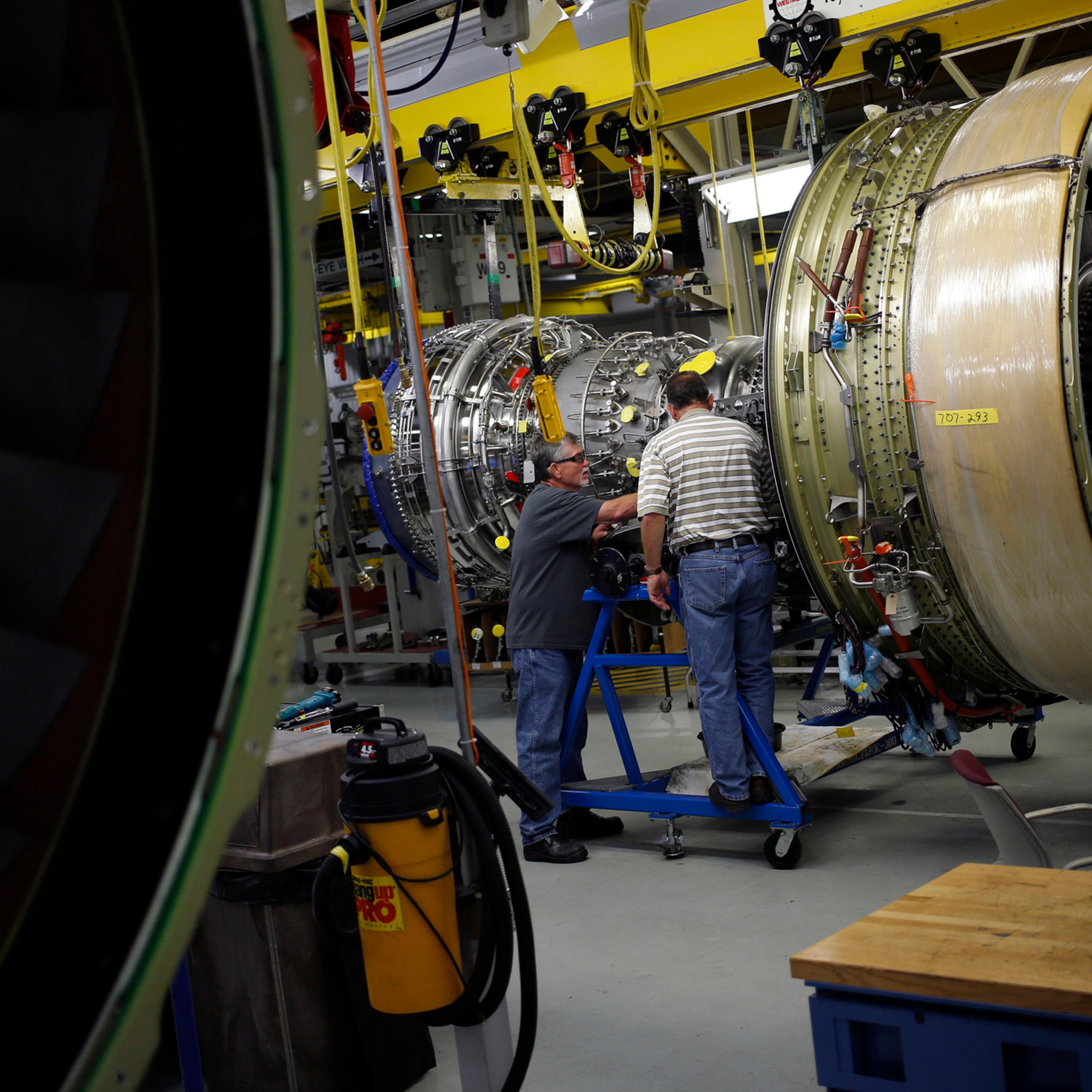 Workers assemble a General Electric Co. CF6-80C2 jet engine at the GE Aviation factory in Cincinnati, Ohio, June 25, 2014.